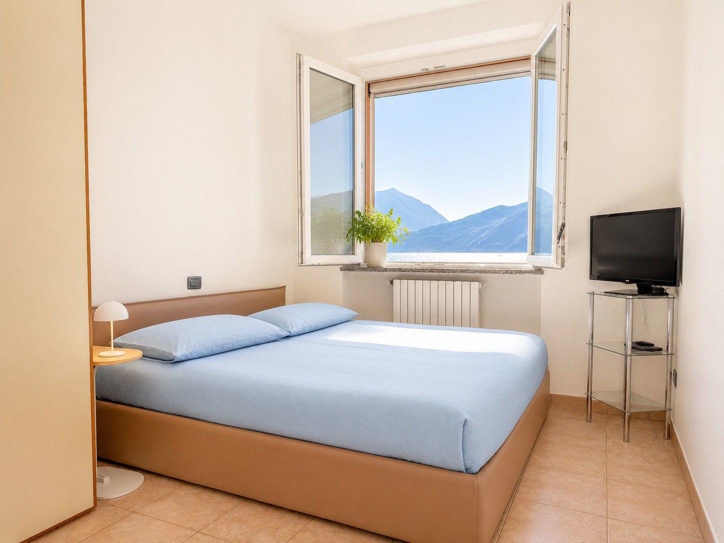 lichtdurchflutetes Schlafzimmer mit weichen hellblauen Doppelbett