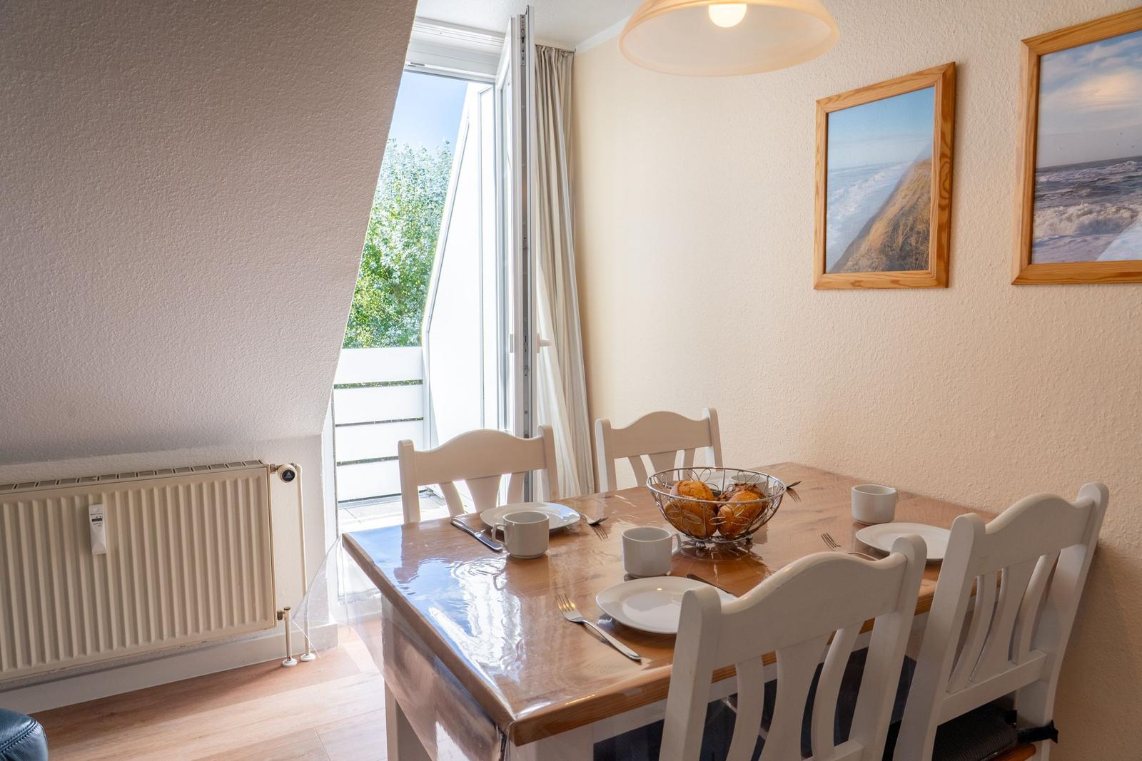 Esstisch mit Stühlen, Fenster und Wandbilder