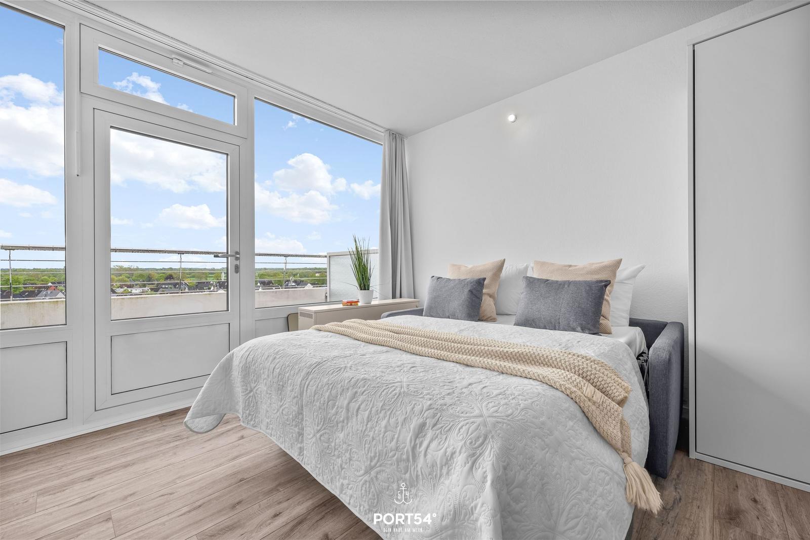 Bedroom with balcony and view of the landscape.