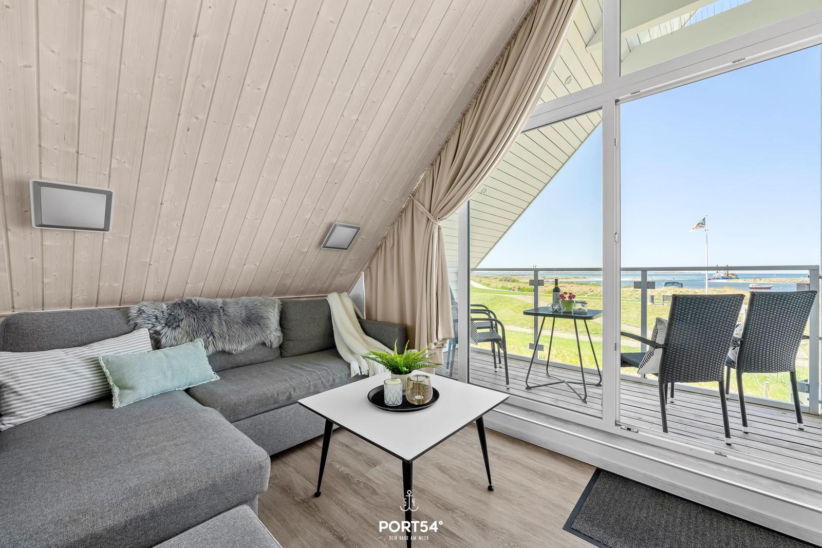 Wohnbereich mit Sofa und Balkonblick auf See