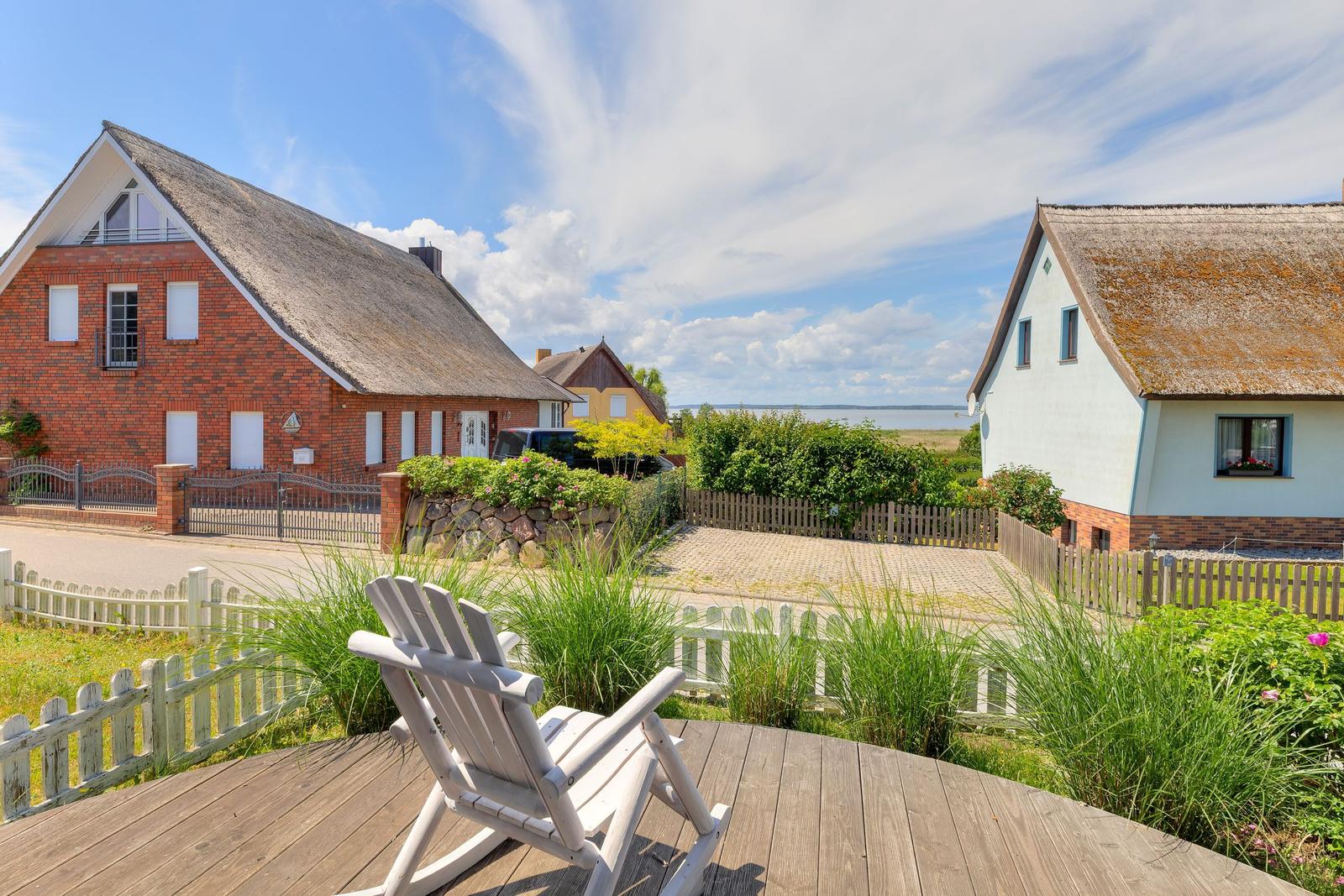Holzterrasse mit Stuhl, Blick auf Häuser und Wasser