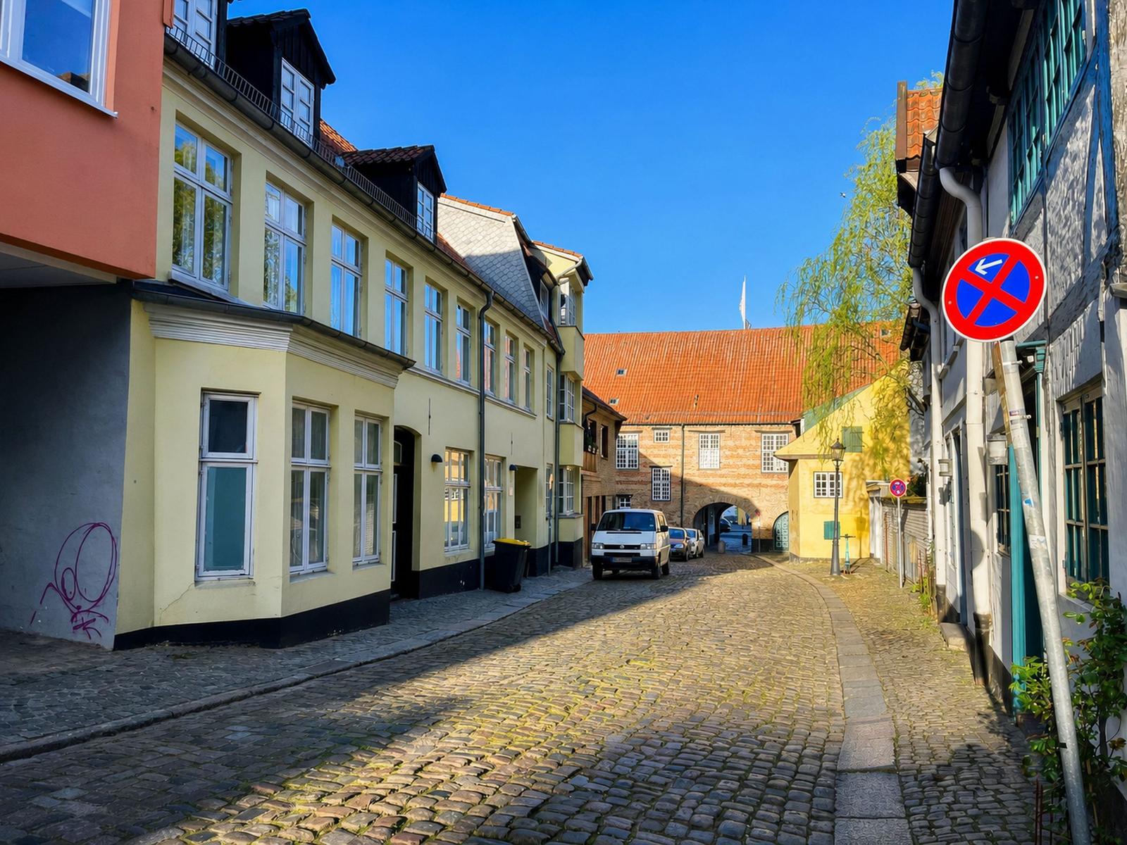 Kobolsteinstraße mit historischen Häusern und einem Tor im Hintergrund.