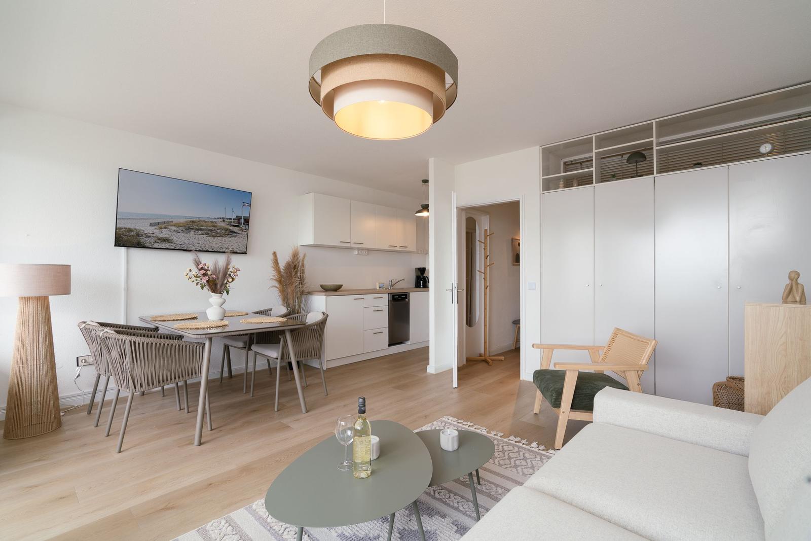 Living and dining area with kitchenette, dining table, and seating.