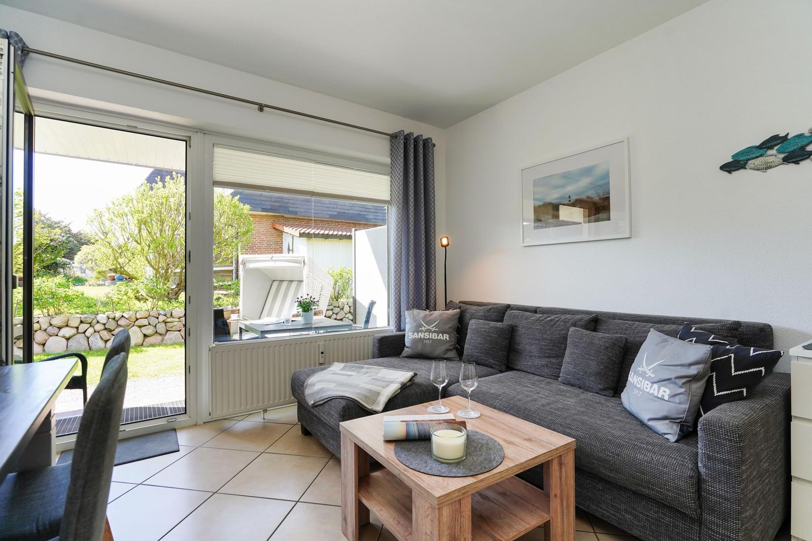 Wohnzimmer mit Sofa, Couchtisch und Blick auf Garten