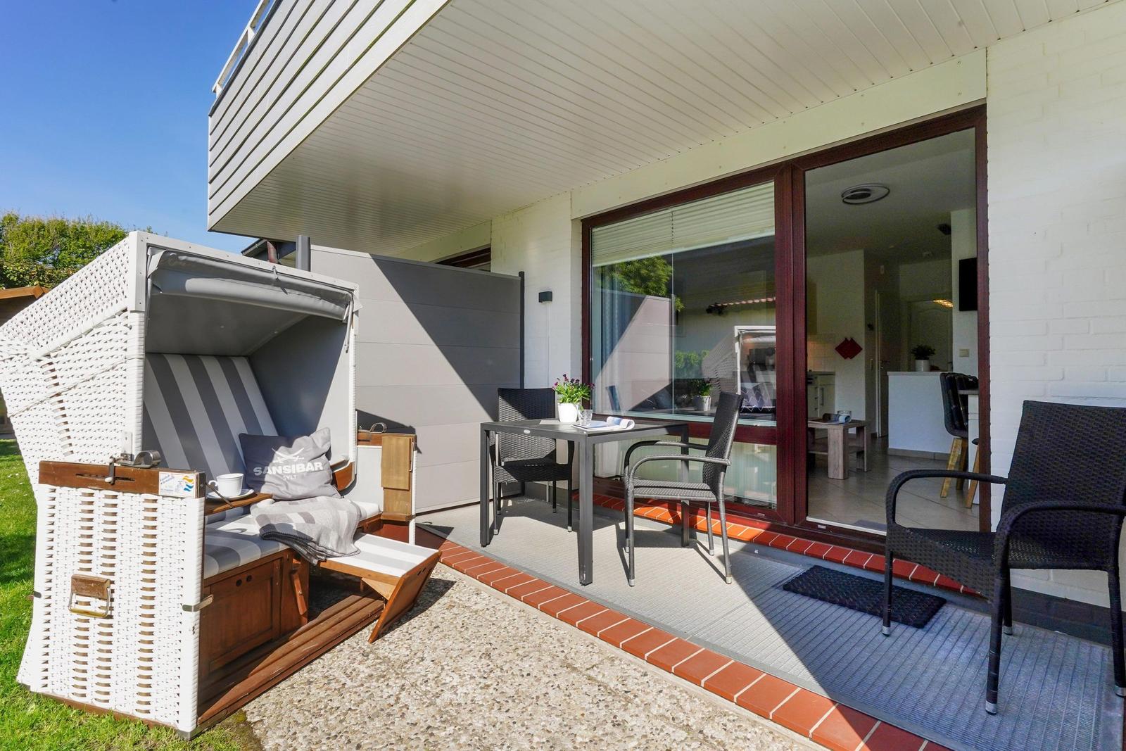Terrasse mit Sitzgruppe, Strandkorb und Blick ins Haus.