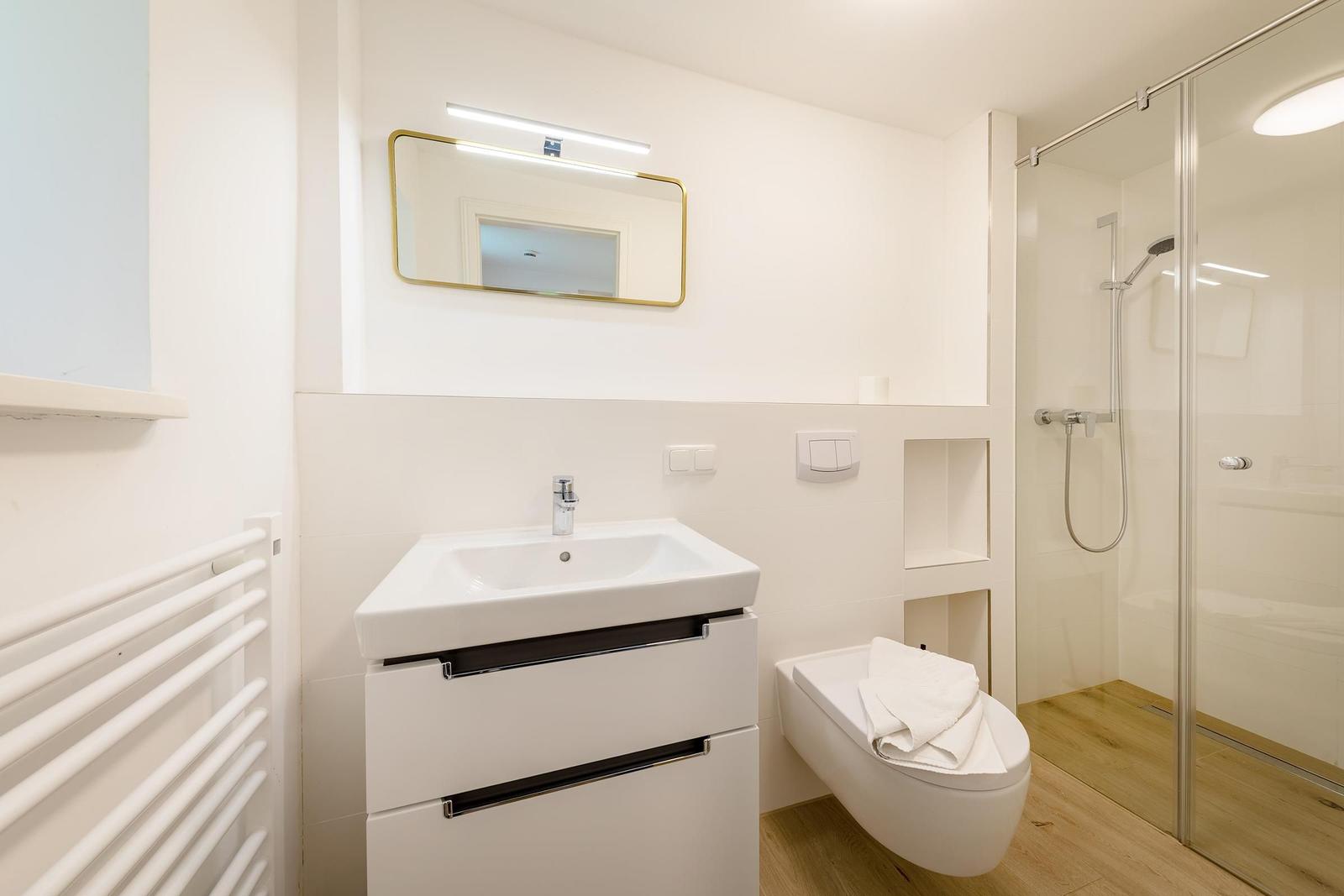 Badezimmer mit Dusche, Waschbecken und Toilette.