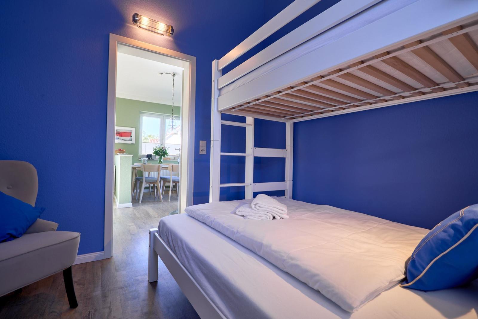 Schlafzimmer mit Doppelbett und Blick in die Küche.