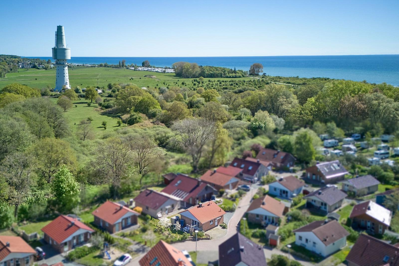 Dorf mit Häusern, Wald und Leuchtturm am Meer