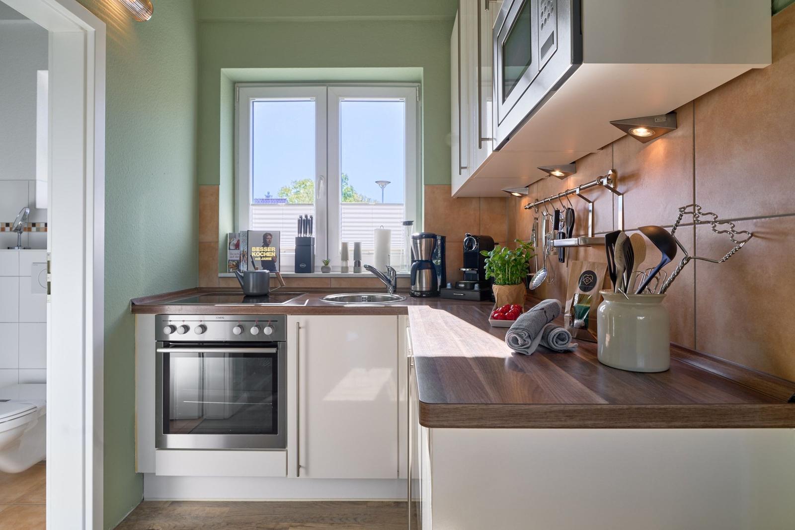 Küche mit Holz Arbeitsplatte, Fenster, Herd und Mikrowelle.