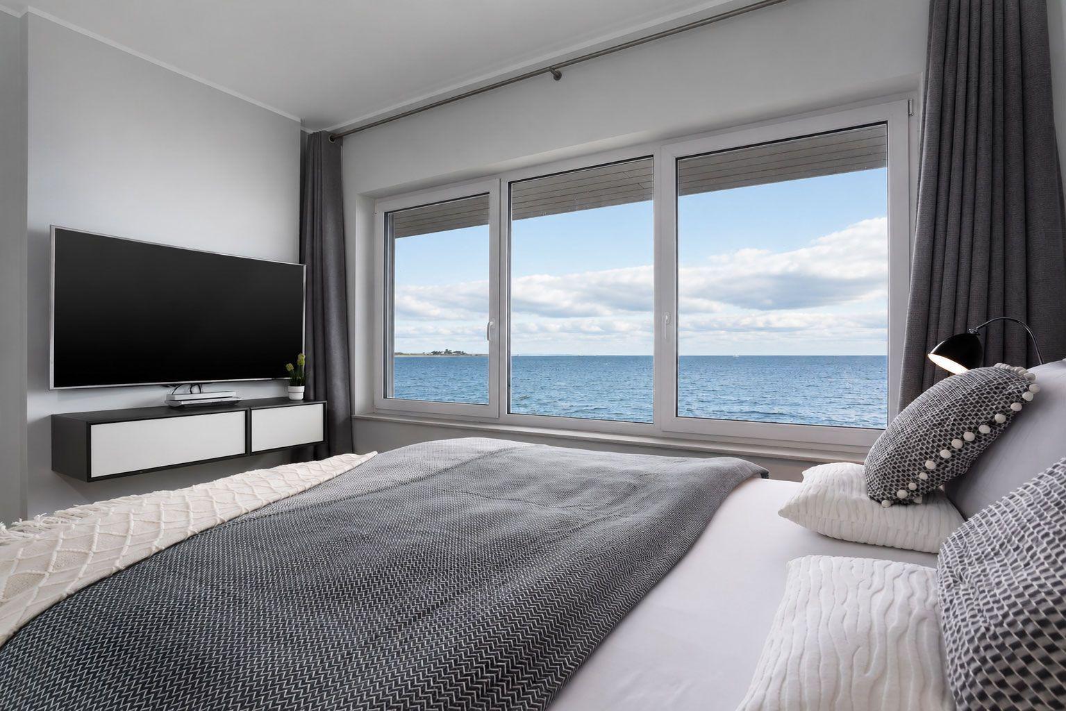 Schlafzimmer mit Blick auf Meer und TV-Wand