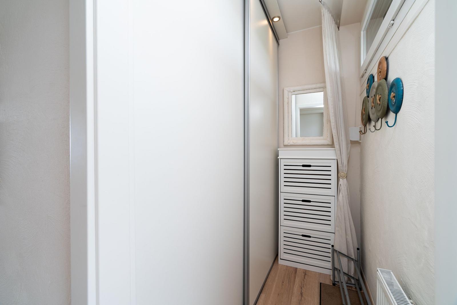 Schlafzimmer mit Kleiderschrank, Spiegelfläche und Wanddekoration.