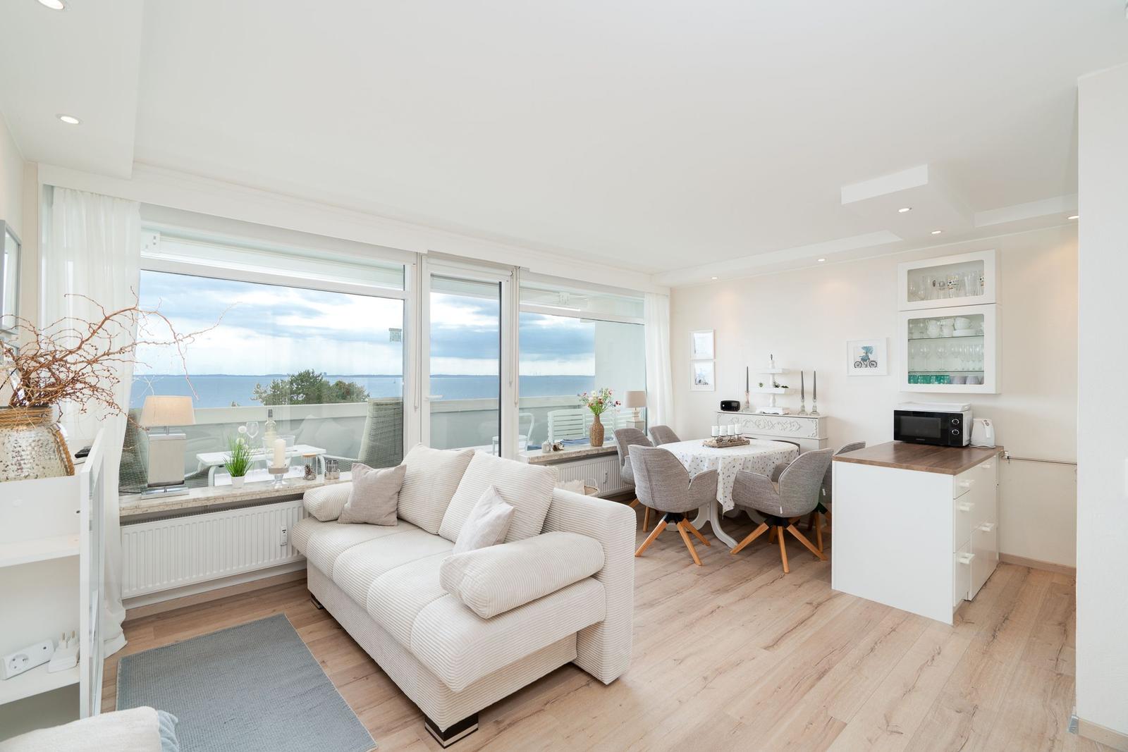 Wohn- und Essbereich mit Blick aufs Meer und großem Fenster