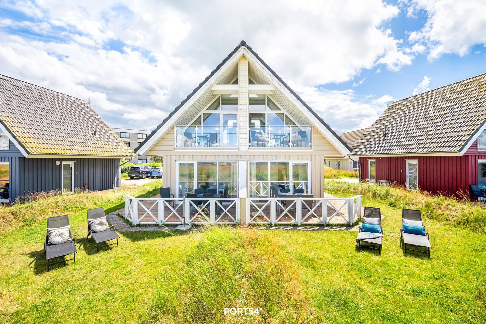 Modernes Haus mit Terrasse und Liegen im Gras
