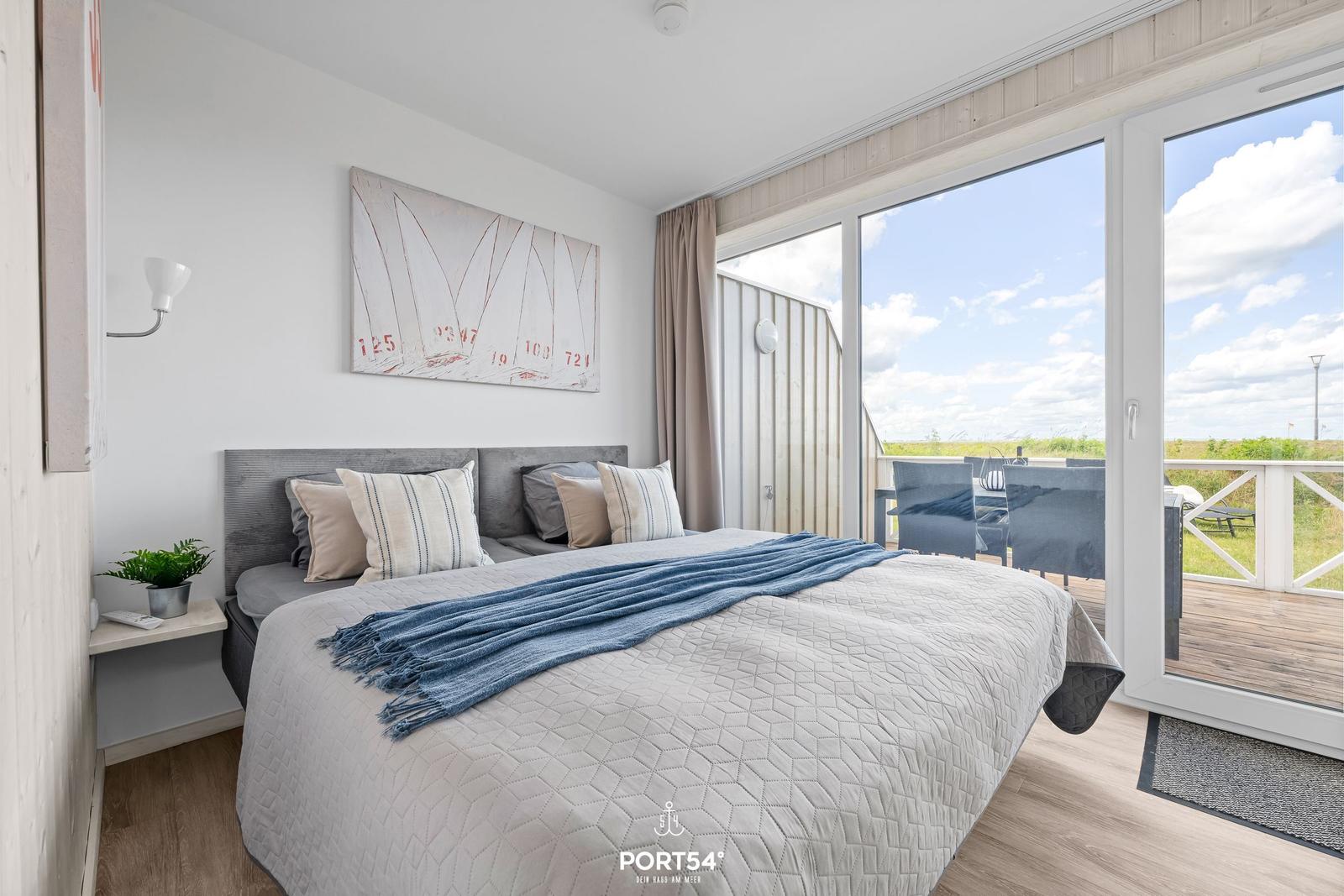 Schlafzimmer mit Blick auf Terrasse und Grünland.