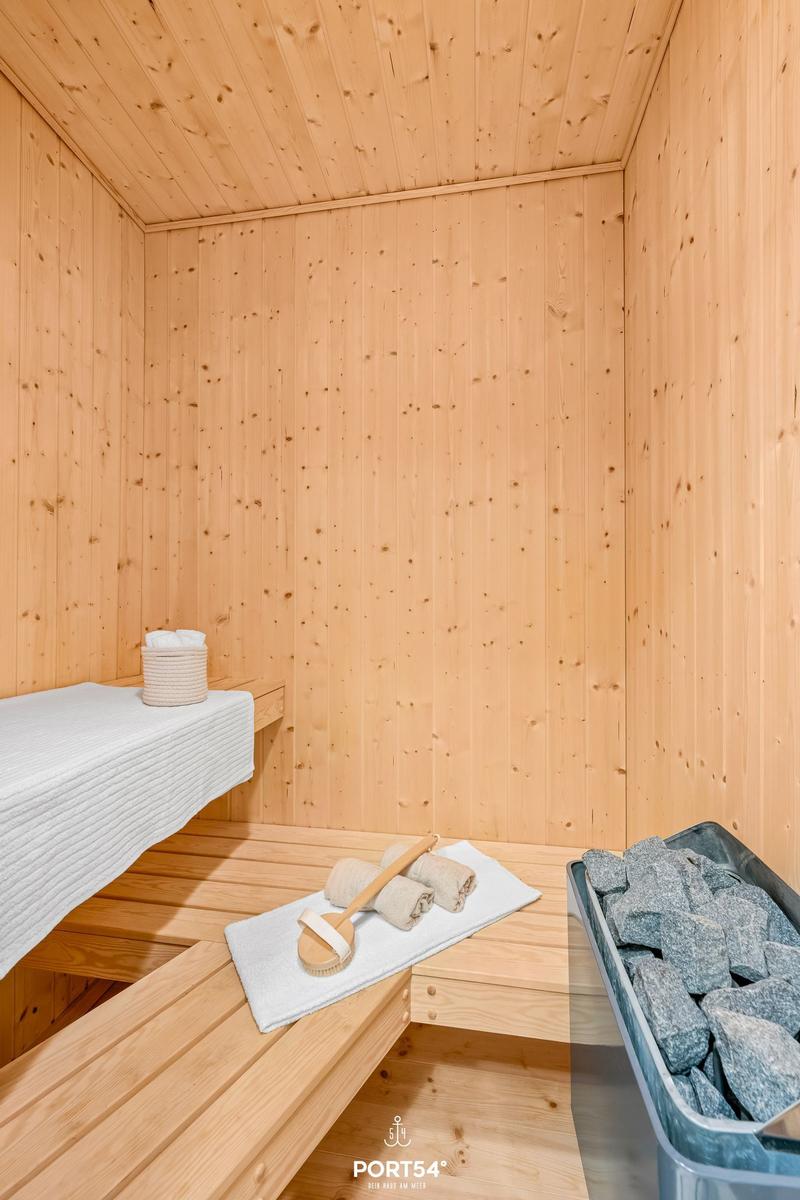 Sauna mit Holzwand, Bank, Handtuch und Steinmulde