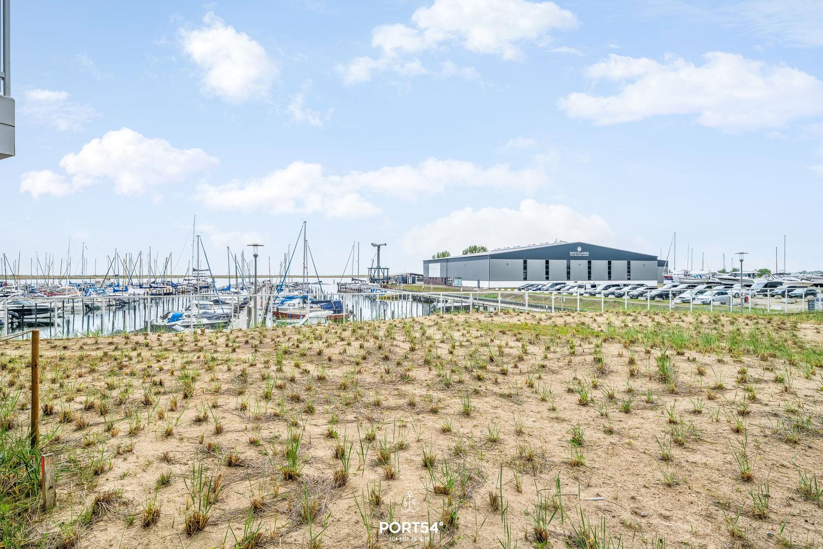 Sandy Fläche mit Blick auf Hafen und Bootshaus.