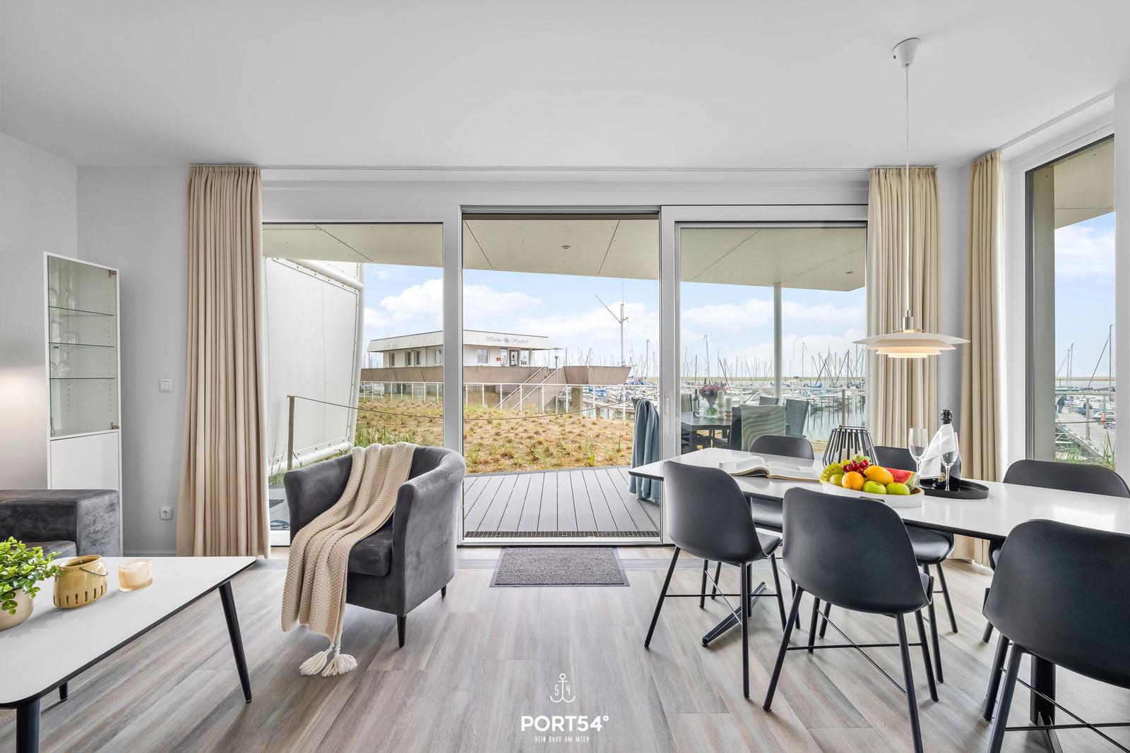 Modernes Wohn- und Esszimmer mit Blick auf Hafen und Yachten.