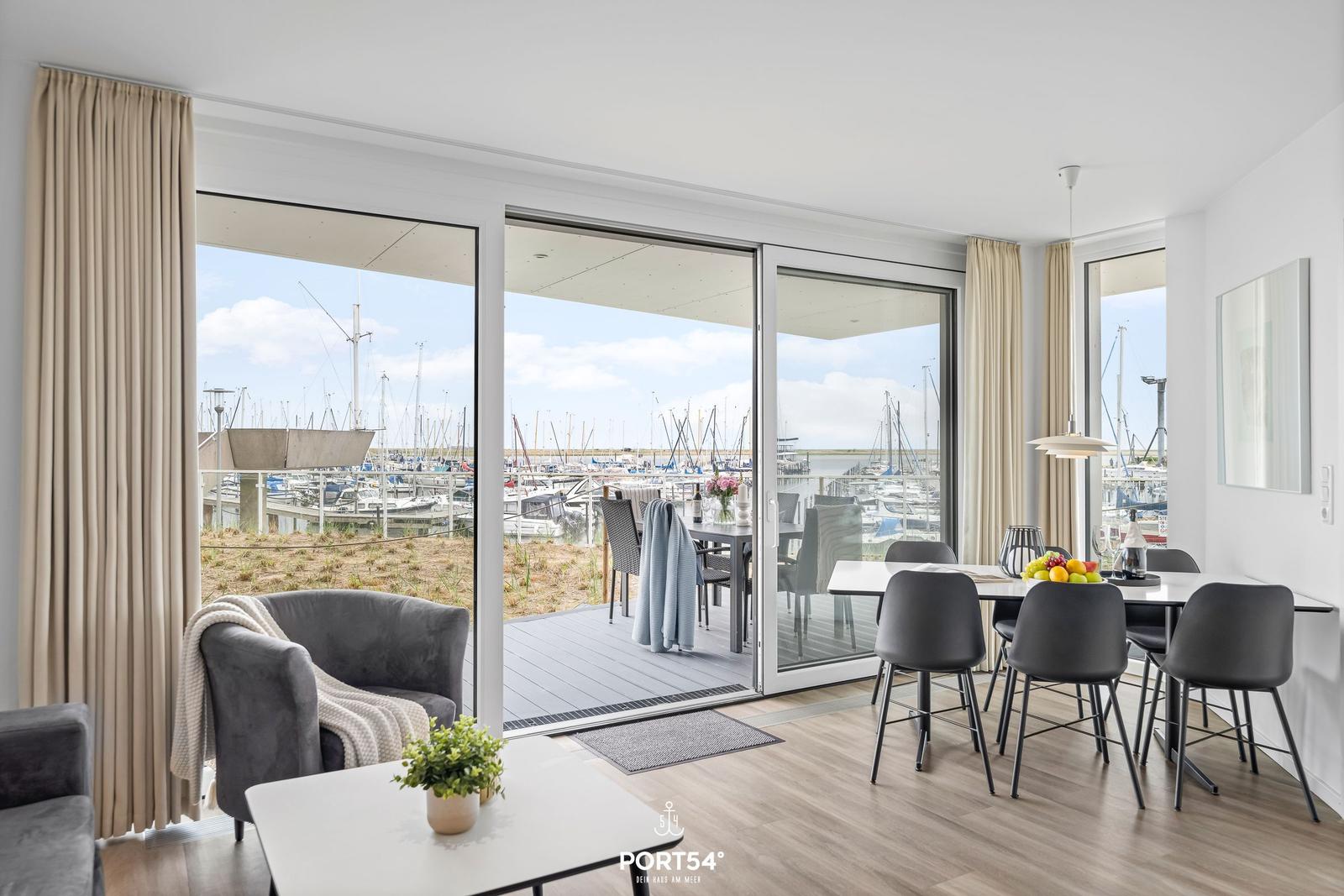 Modern eingerichtetes Wohn- und Esszimmer mit Blick auf den Hafen.