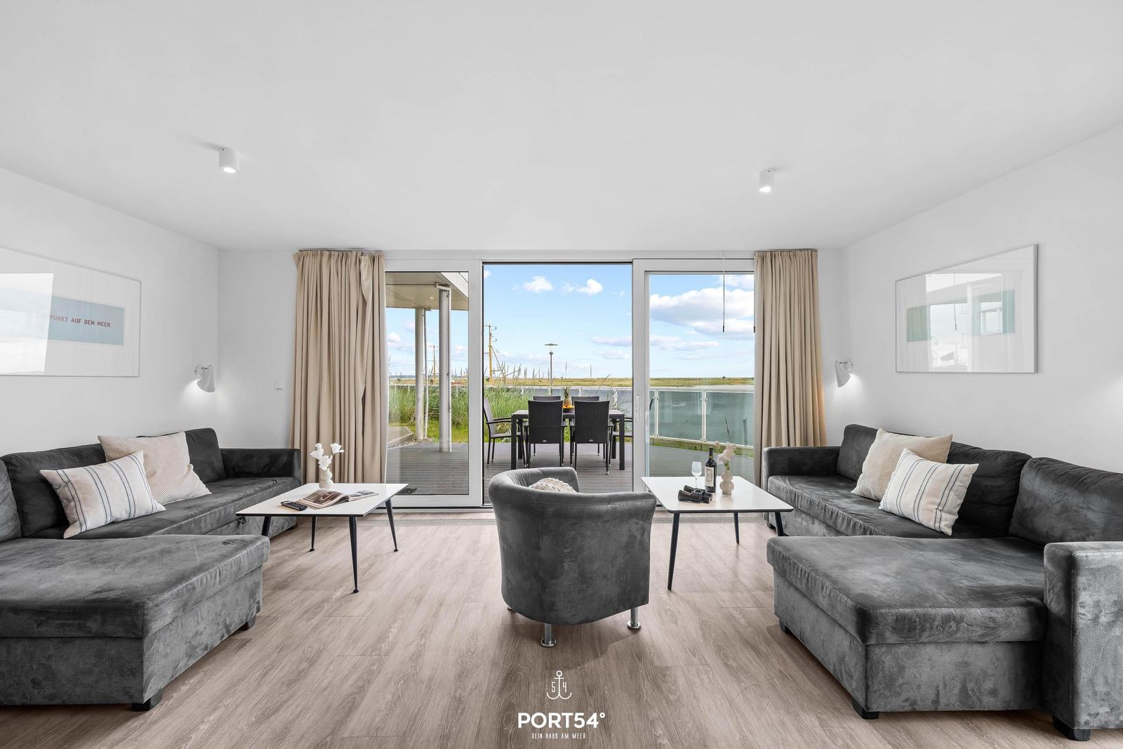 Wohnbereich mit zwei Sofas, Sitzgelegenheit und Blick auf die Terrasse.