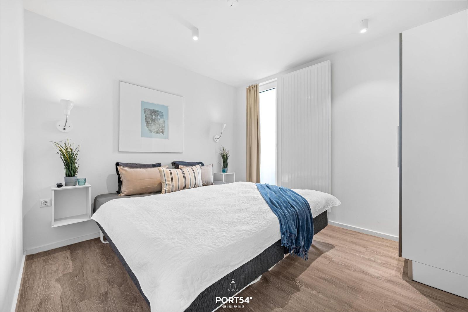 Schlafzimmer mit Bett, Wandbild, Nachttisch und Fenster