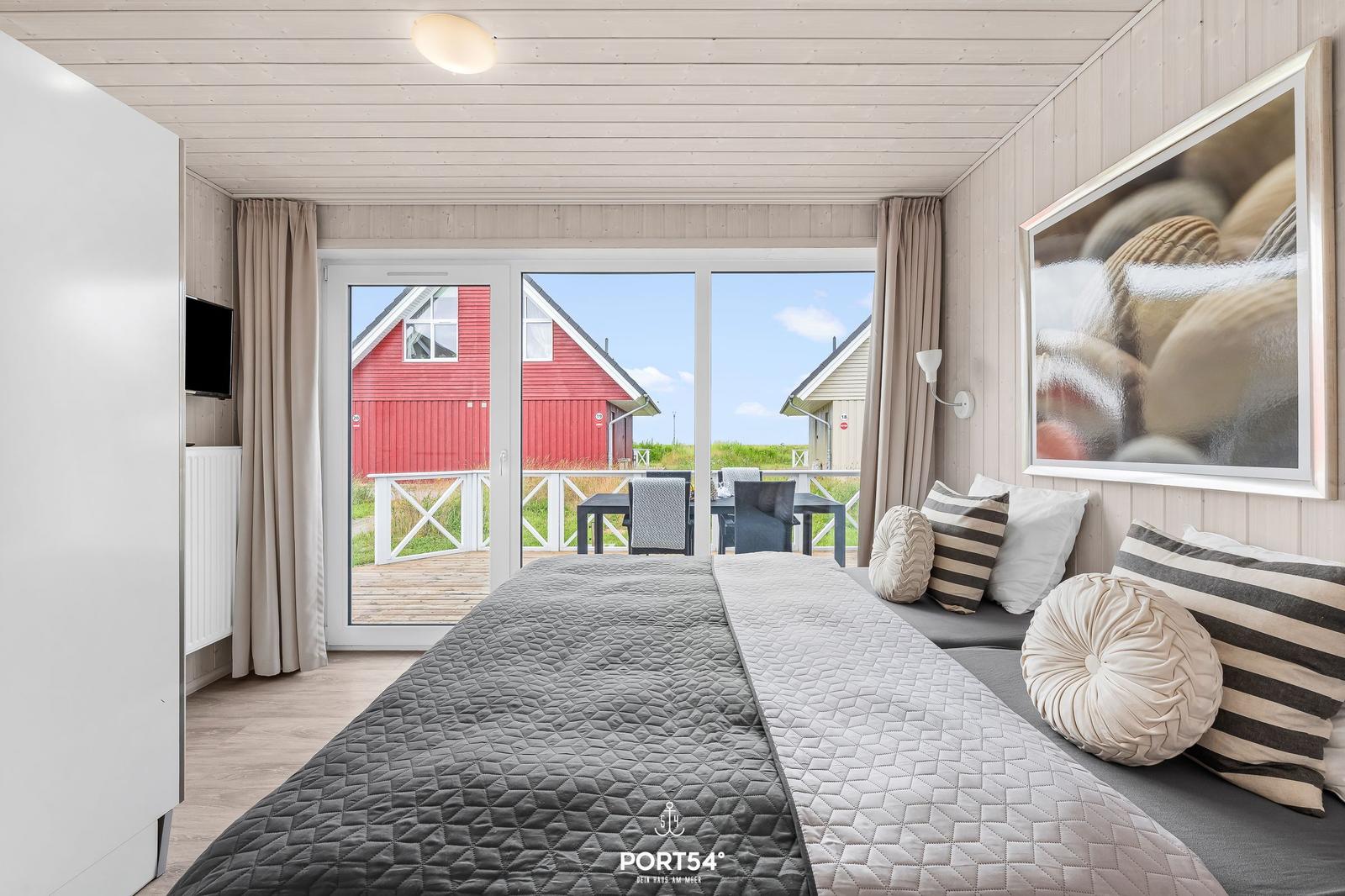 Schlafzimmer mit Blick auf rote Häuser und Terrasse