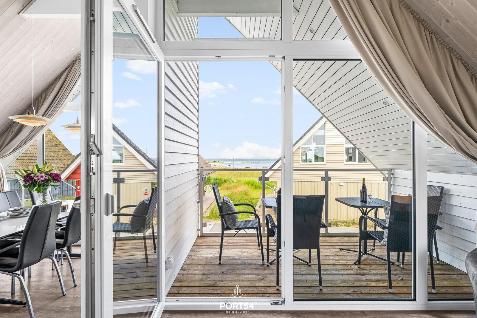 Terrasse mit Sitzgelegenheiten und Blick auf das Meer.