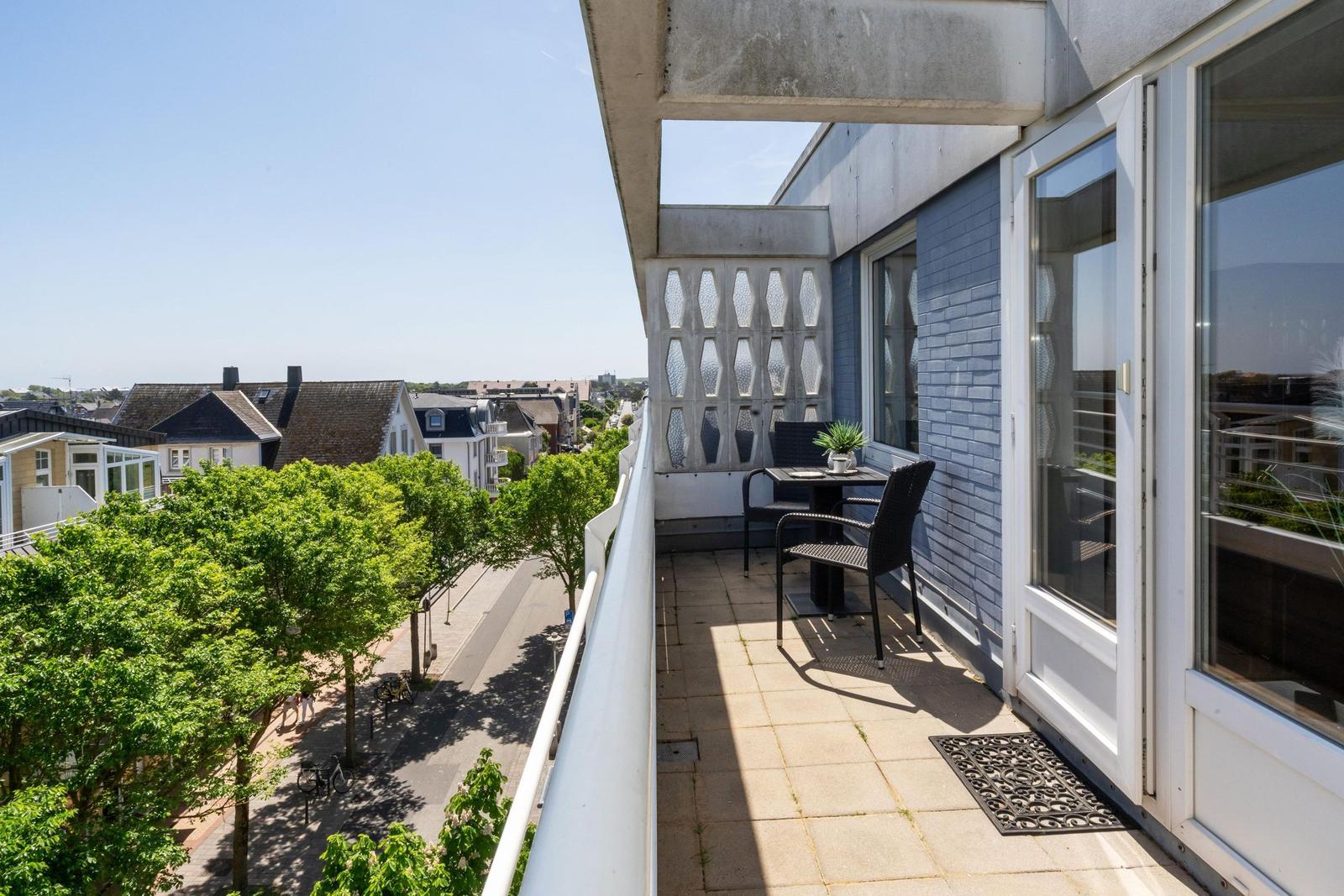 Terrasse mit Tisch, zwei Stühlen und Blick auf Straßen und Häuser