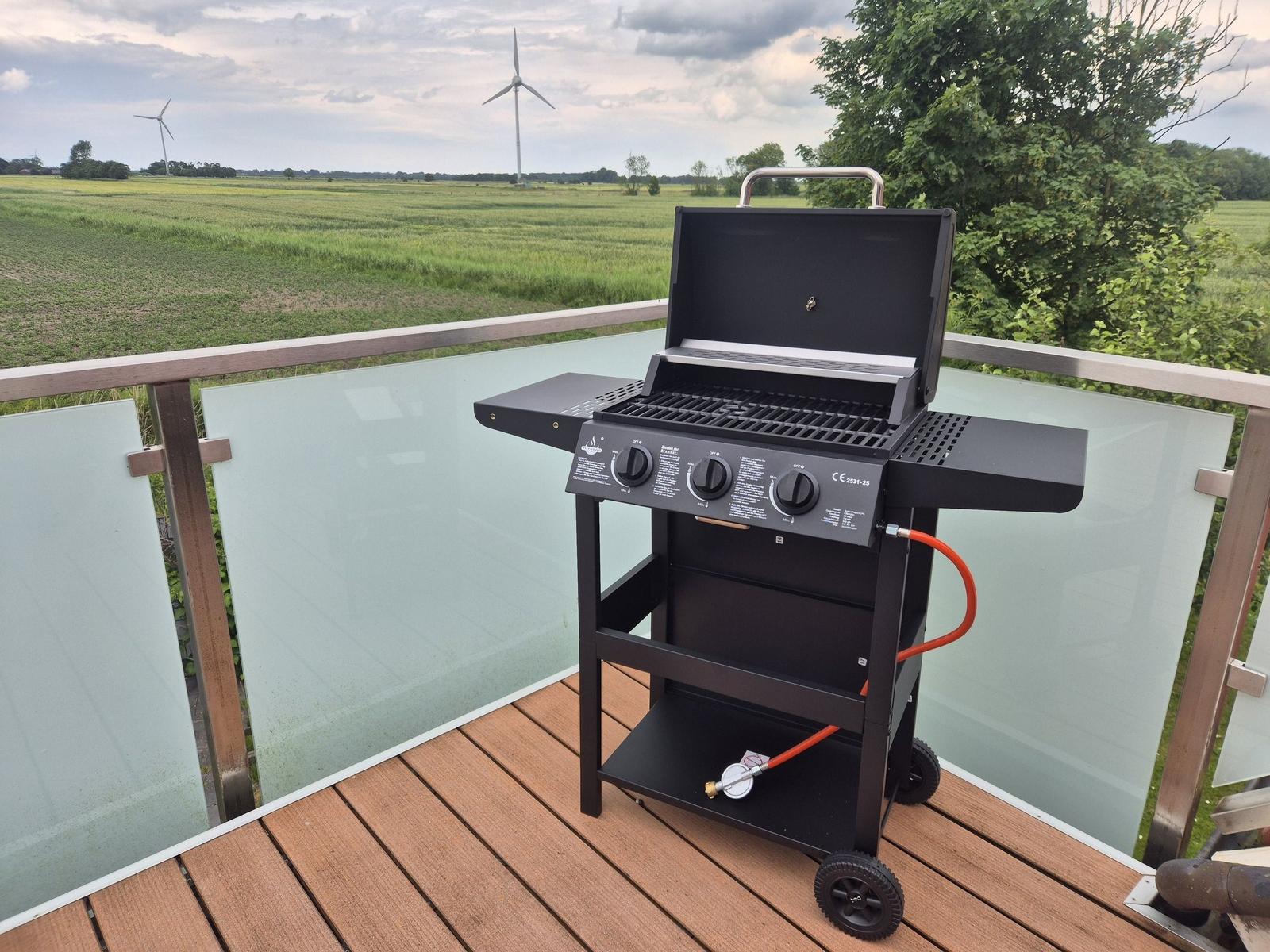 Gasherd auf Terrasse mit Blick auf Feld und Windräder.