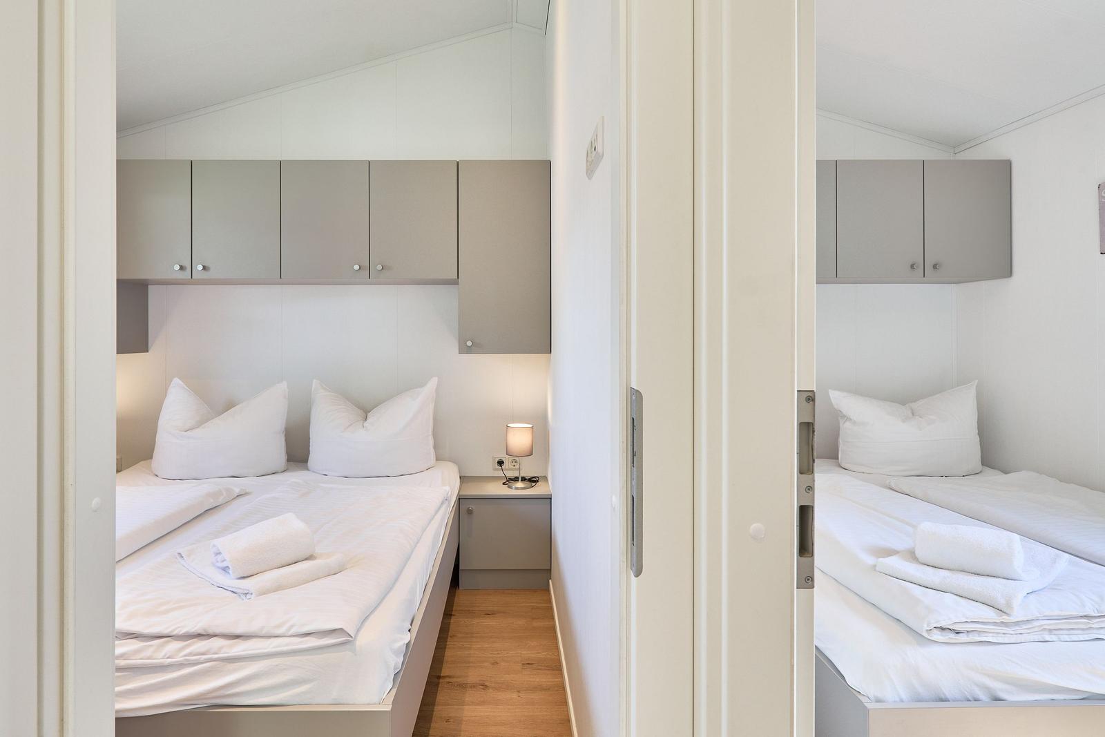 Zwei Schlafzimmer mit jeweils einem Bett und Schrank über dem Bett.