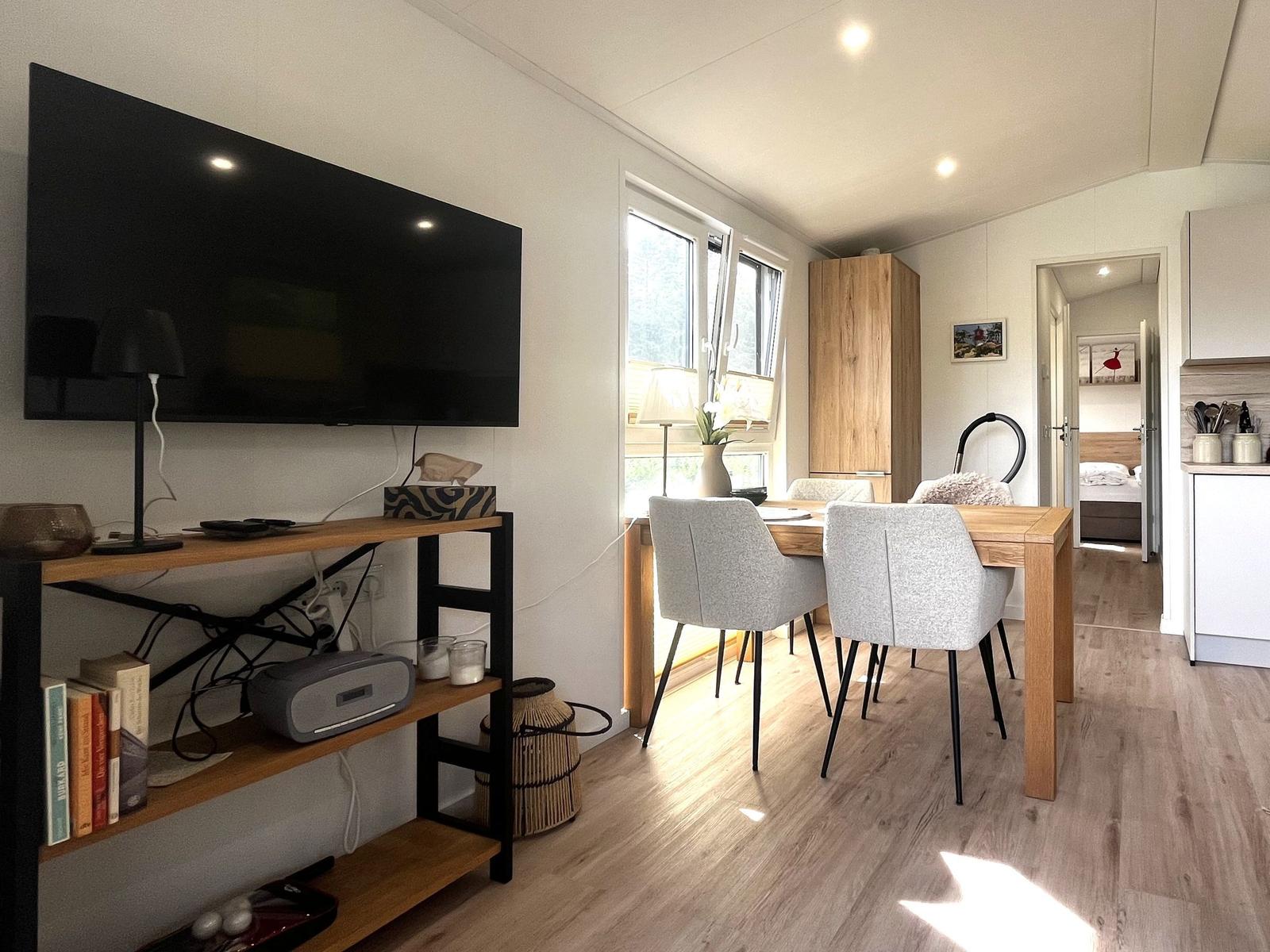 Wohnbereich mit TV, Esstisch und Blick in Schlafzimmer