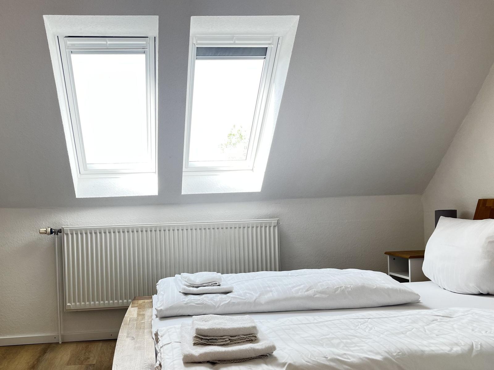 Schlafzimmer mit Dachfenstern, Bett und Heizkörper