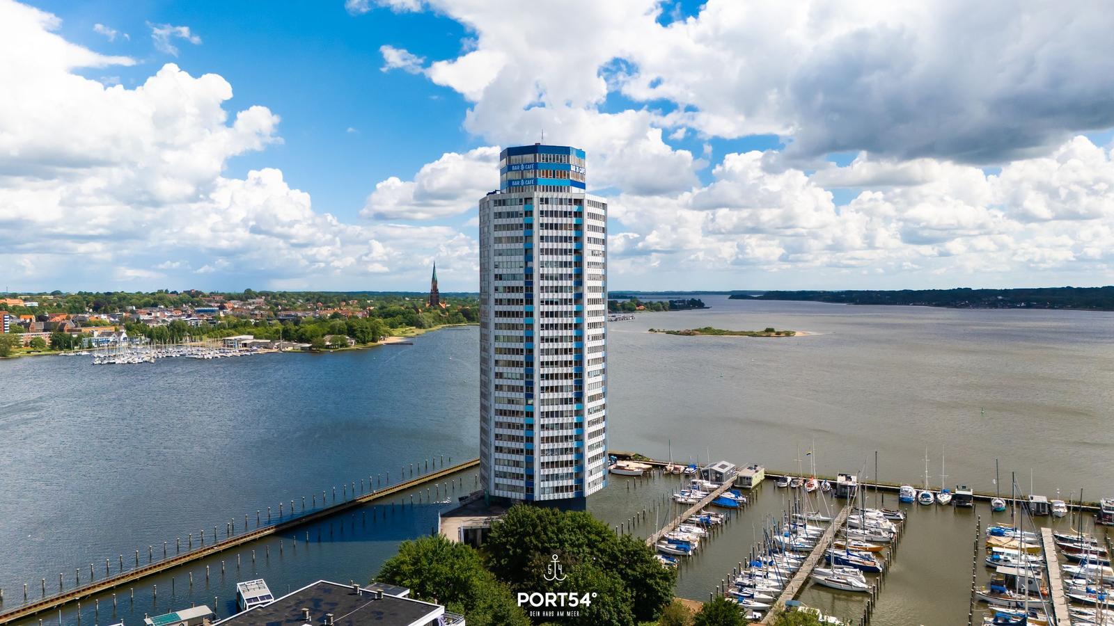Hochhaus am Hafen mit Booten und Wasserlandschaft