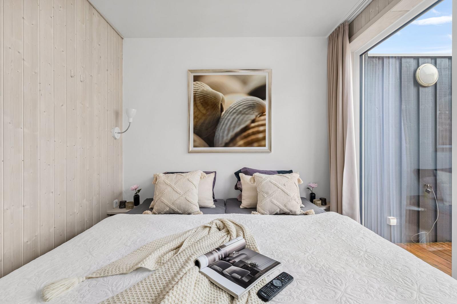 Schlafzimmer mit Bett, Wandbild und Balkonansicht