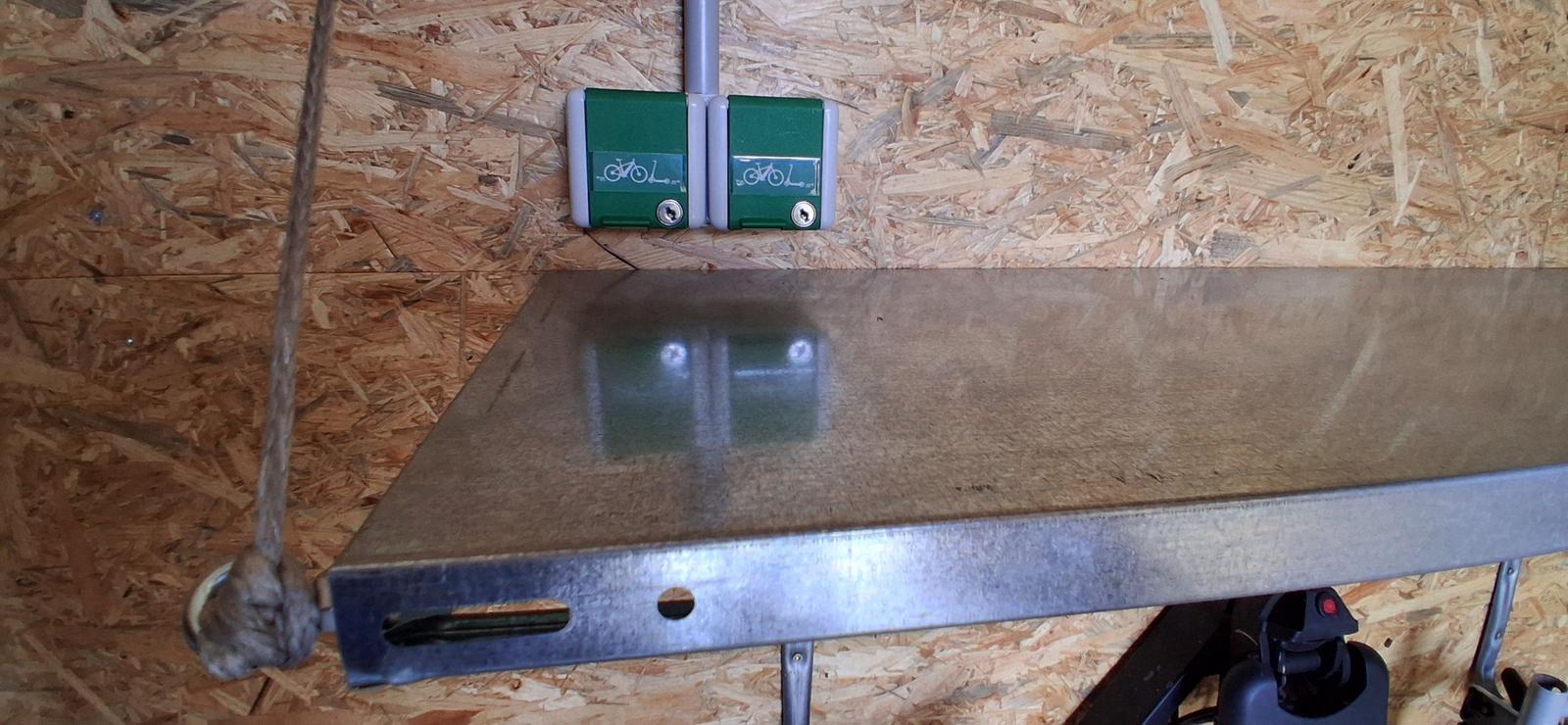 Metallboden mit zwei grünen Fahrradhalterungen an OSB-Wand