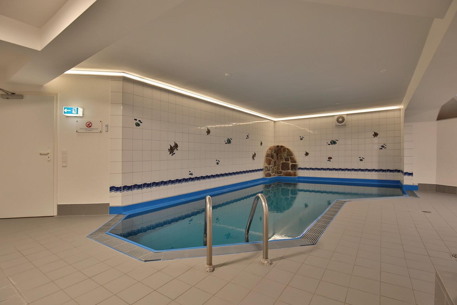 Innenpool mit Wandfliesen und Metalltreppe