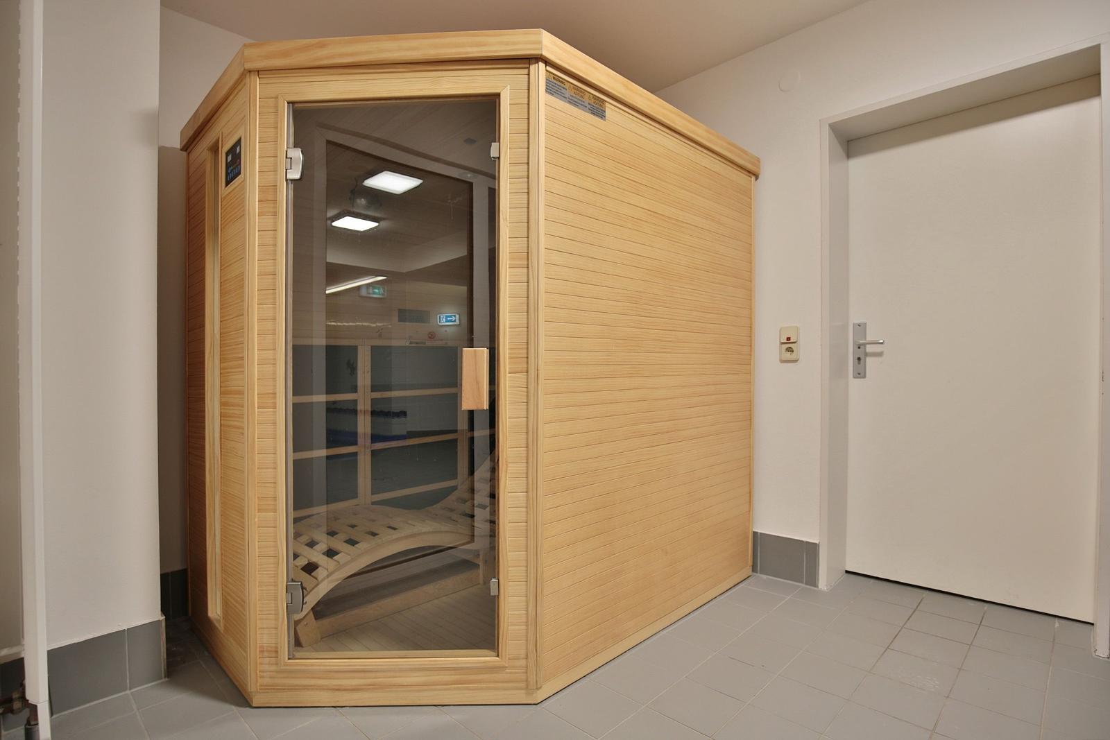 Holzsauna mit Glasfront und Sitzbank im Innenraum