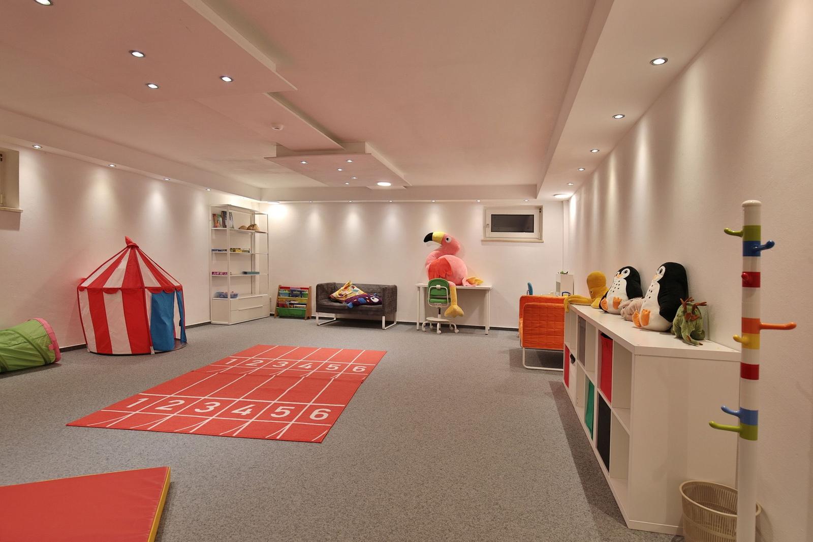 Kinderzimmer mit Spielbereich, Zelt, Matte und Stauraum. Spielzeug und Möbel sind sichtbar.