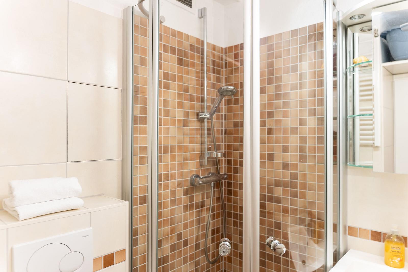 Bad mit Dusche, Waschbecken und Handtuch