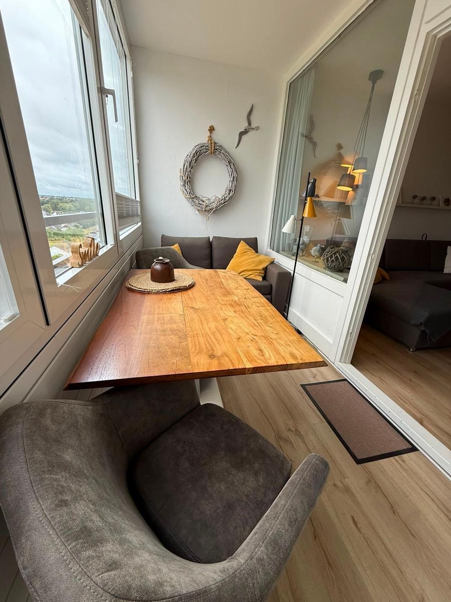 Essbereich mit Holztisch, Sitzgelegenheit und Blick aus dem Fenster.