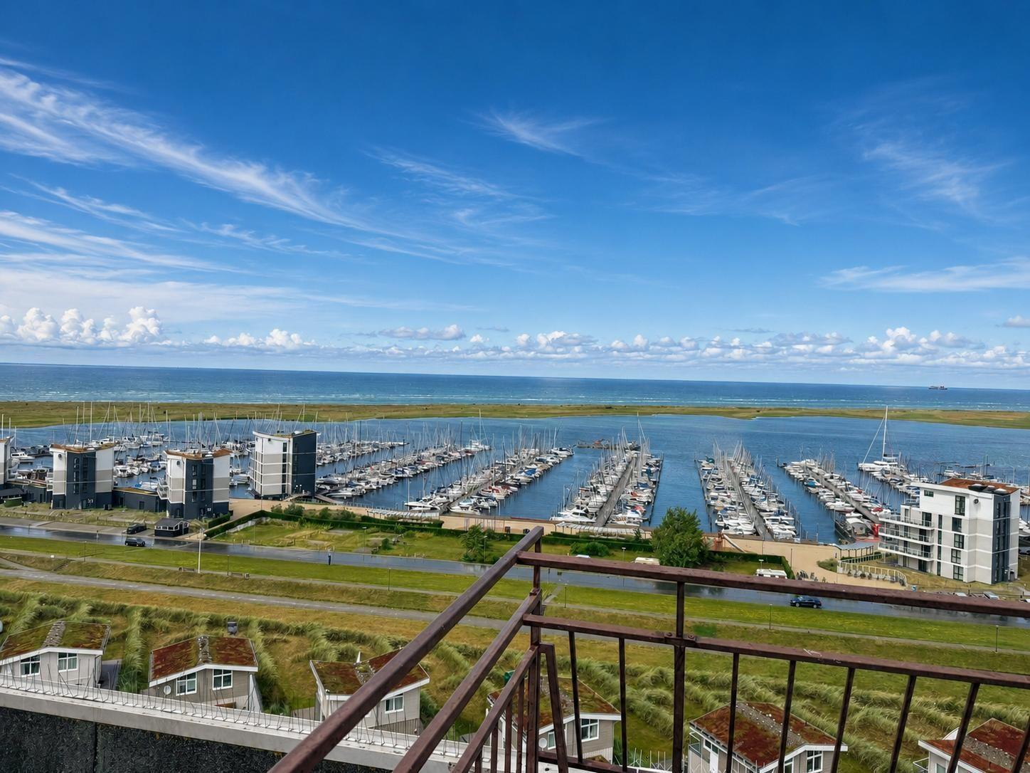 Blick auf Hafen mit Booten und Meer unter blauem Himmel