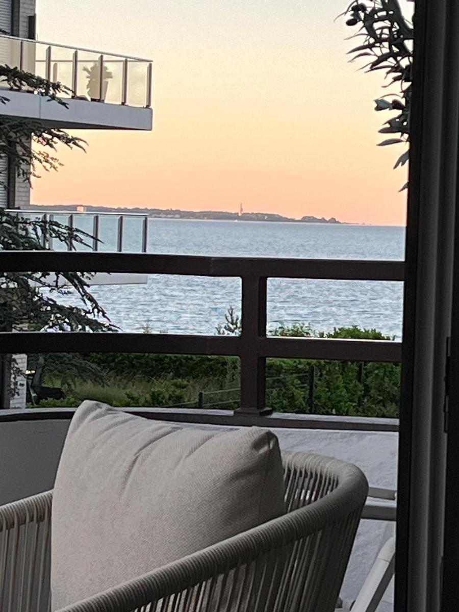 Balkon mit Sicht auf Meer und Sonnenuntergang. Sitzgelegenheit mit Kissen.