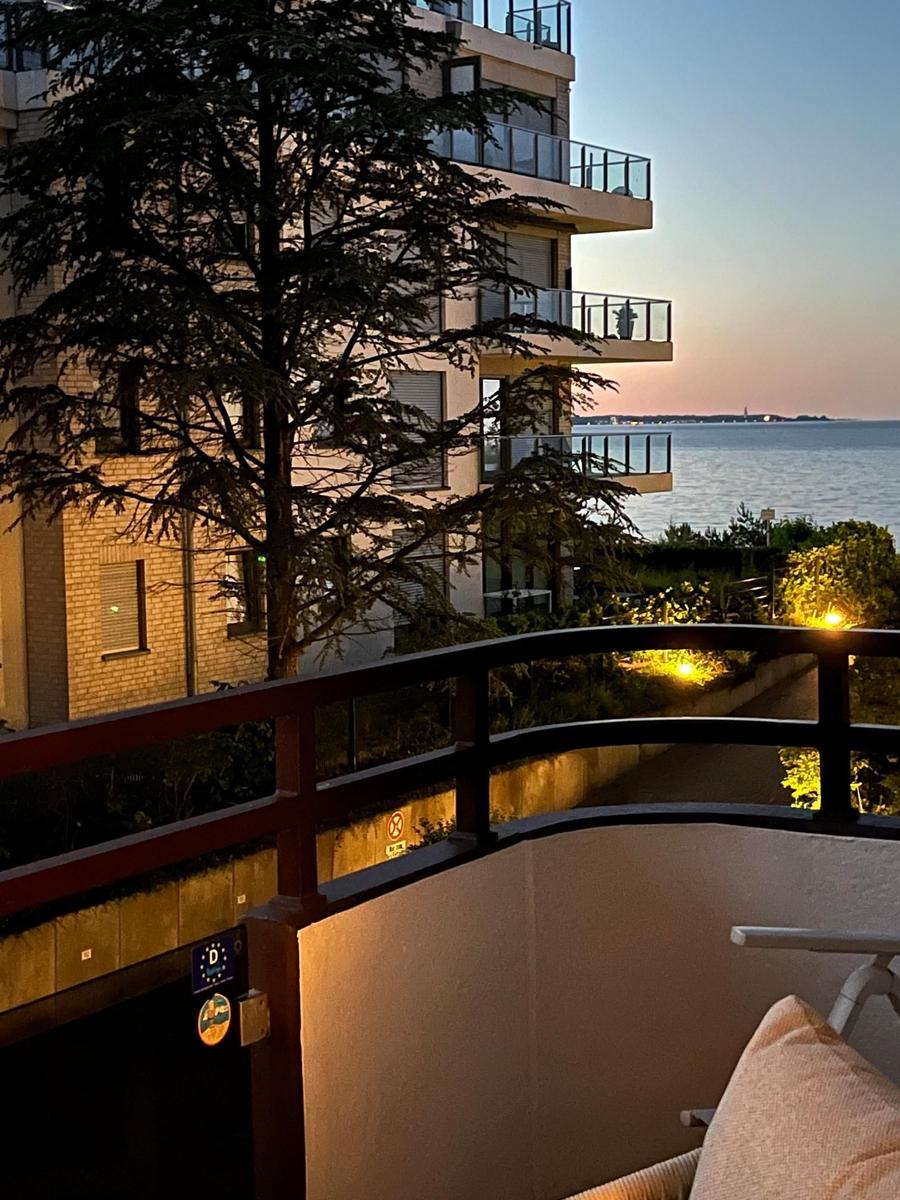 Terrasse mit Blick auf See und Gebäude bei Sonnenuntergang.