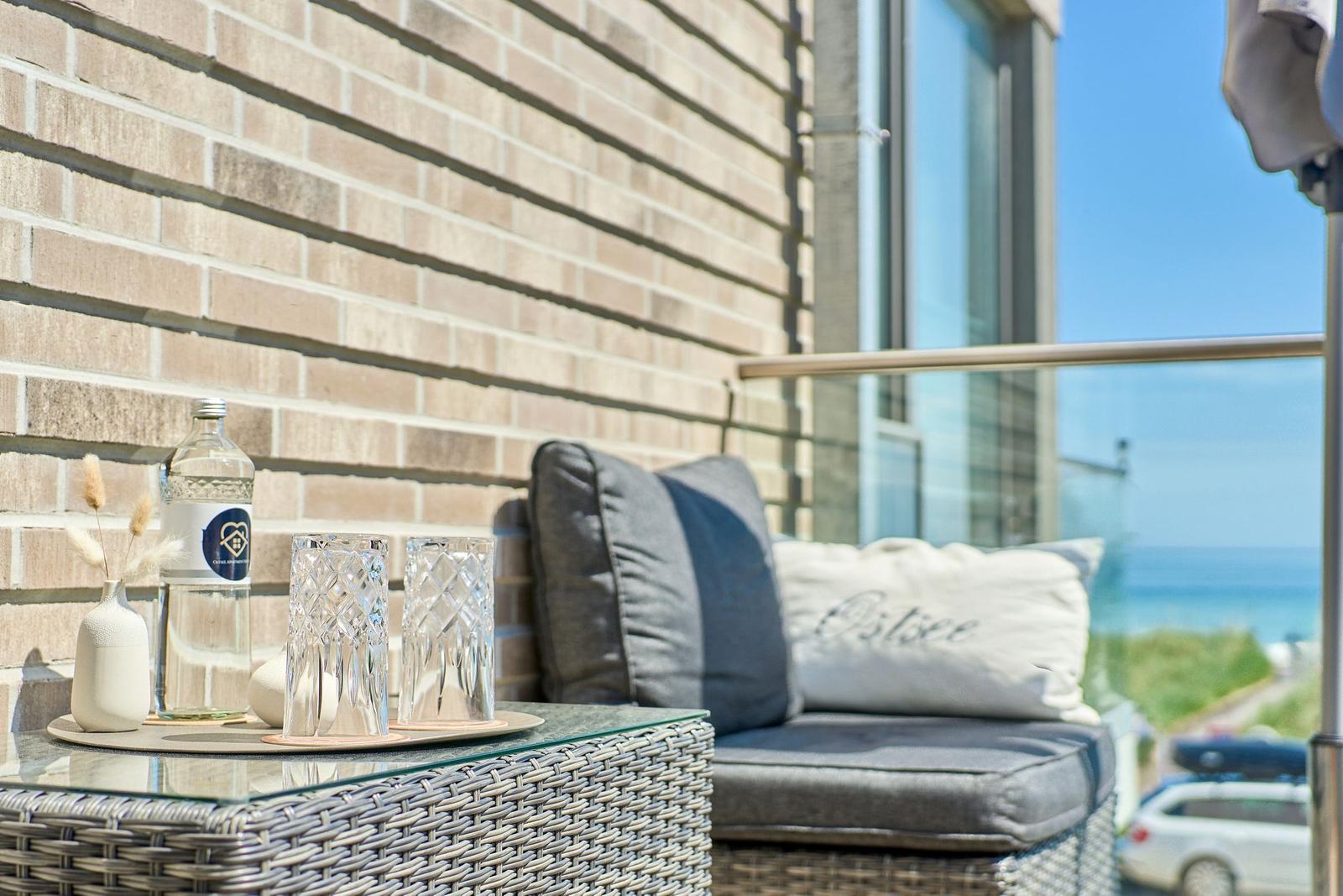 Terrasse mit Sitzmöbeln, Tisch und Meerblick.