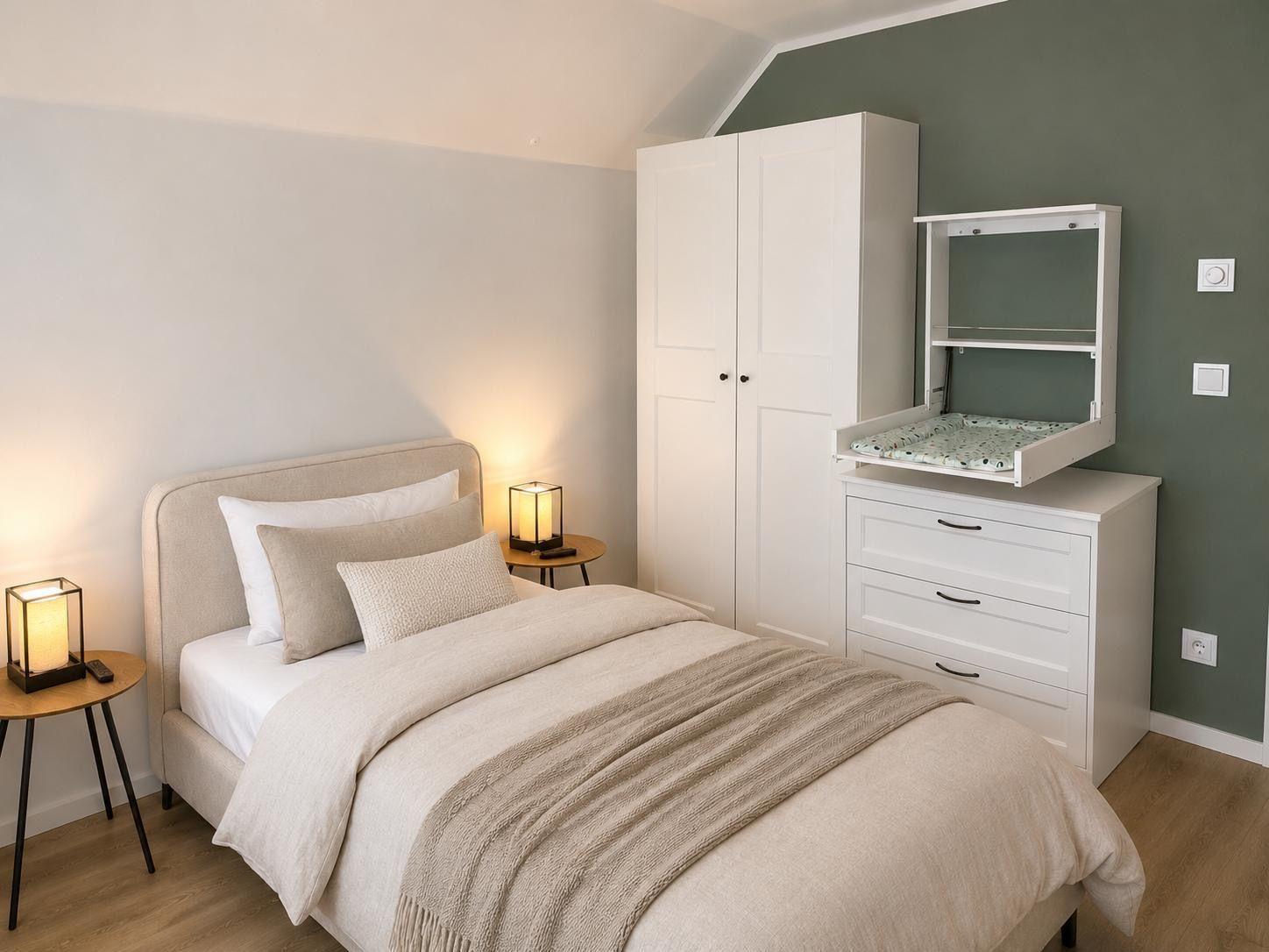 Schlafzimmer mit Bett, Nachttisch, Kleiderschrank und Wickelkommode.