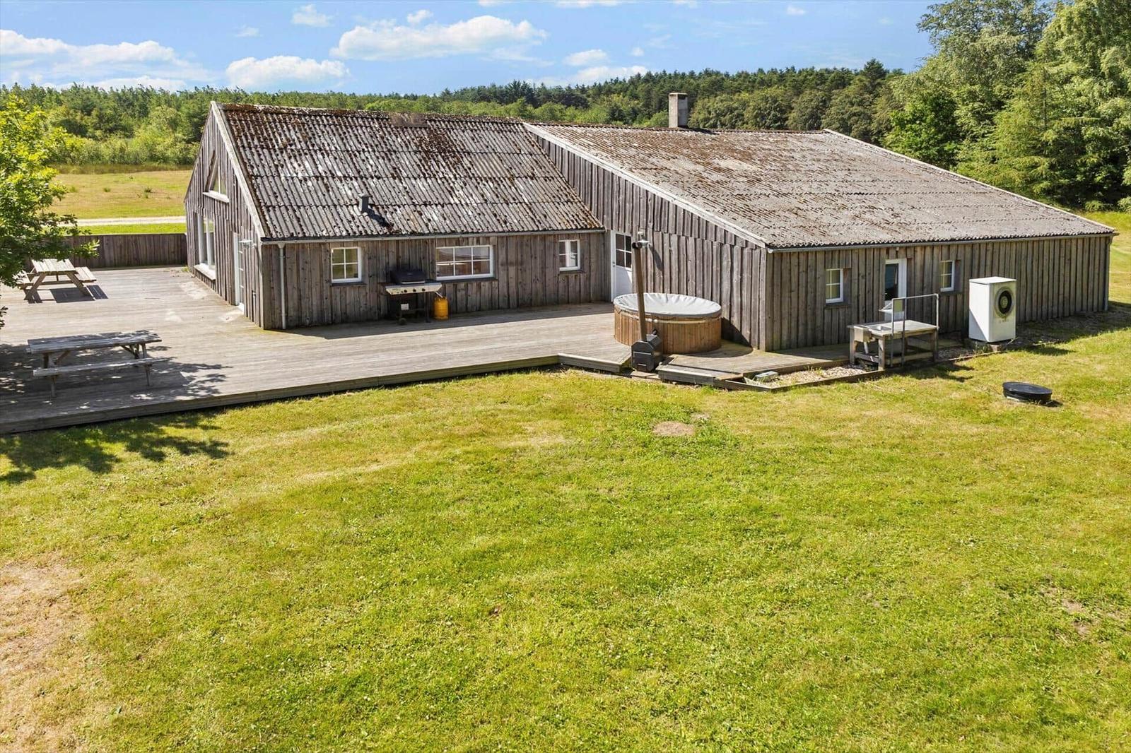 Holzhaus mit Terrasse, Whirlpool und Grillplatz im Grünen.