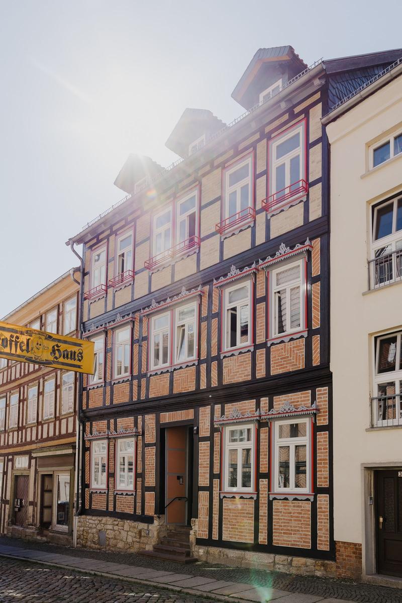 Traditionelles Fachwerkhaus mit mehreren Fenstern und Dachgauben an der Straße.