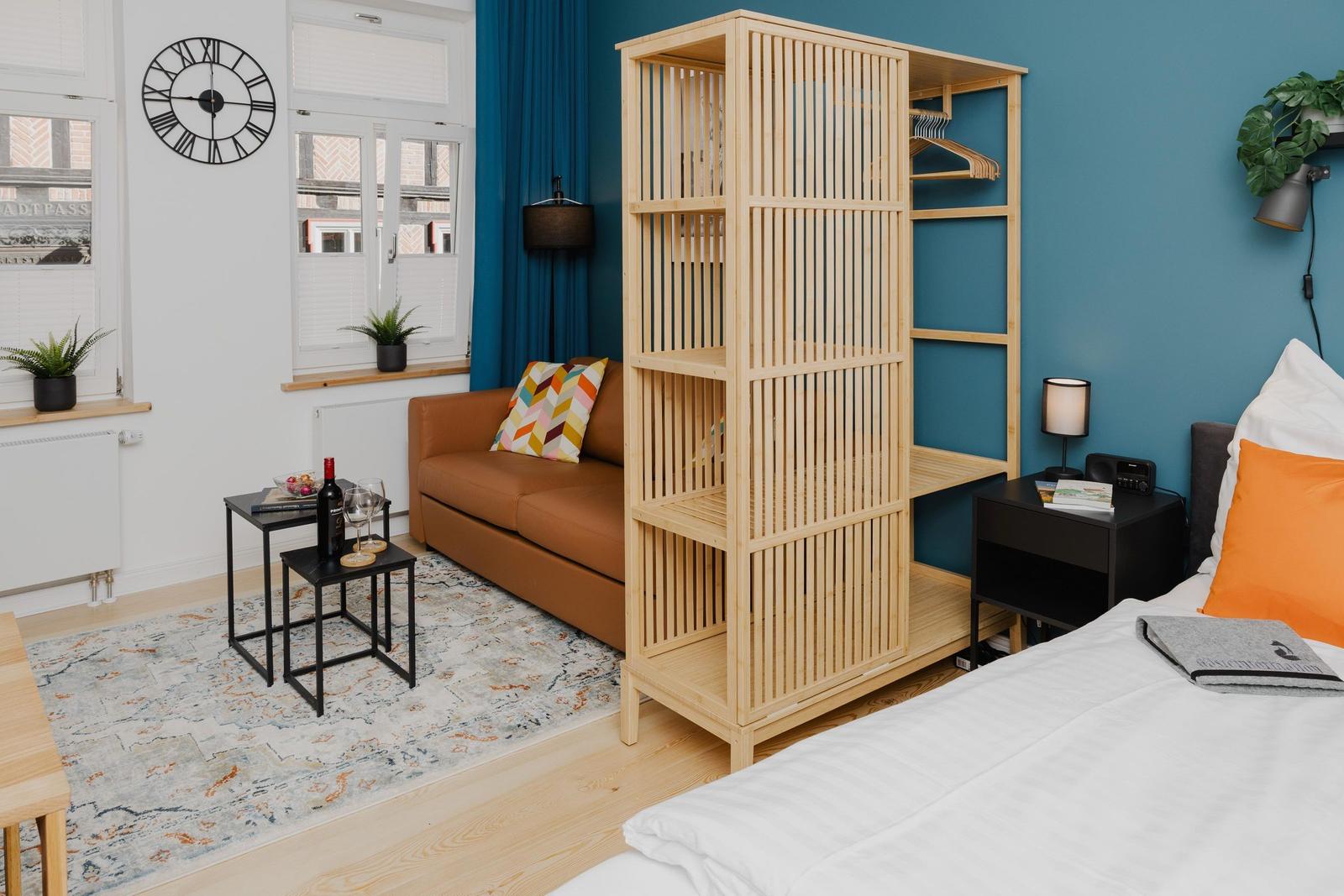 Schlafzimmer mit Bett, Couch, Kleiderschrank und Fenster mit Blick.