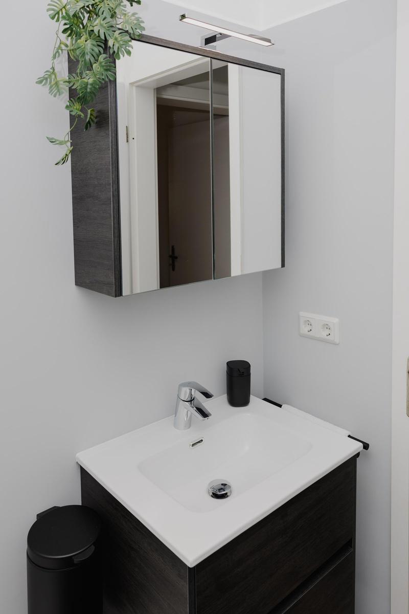 Dusche mit Spiegelschrank und Waschbecken