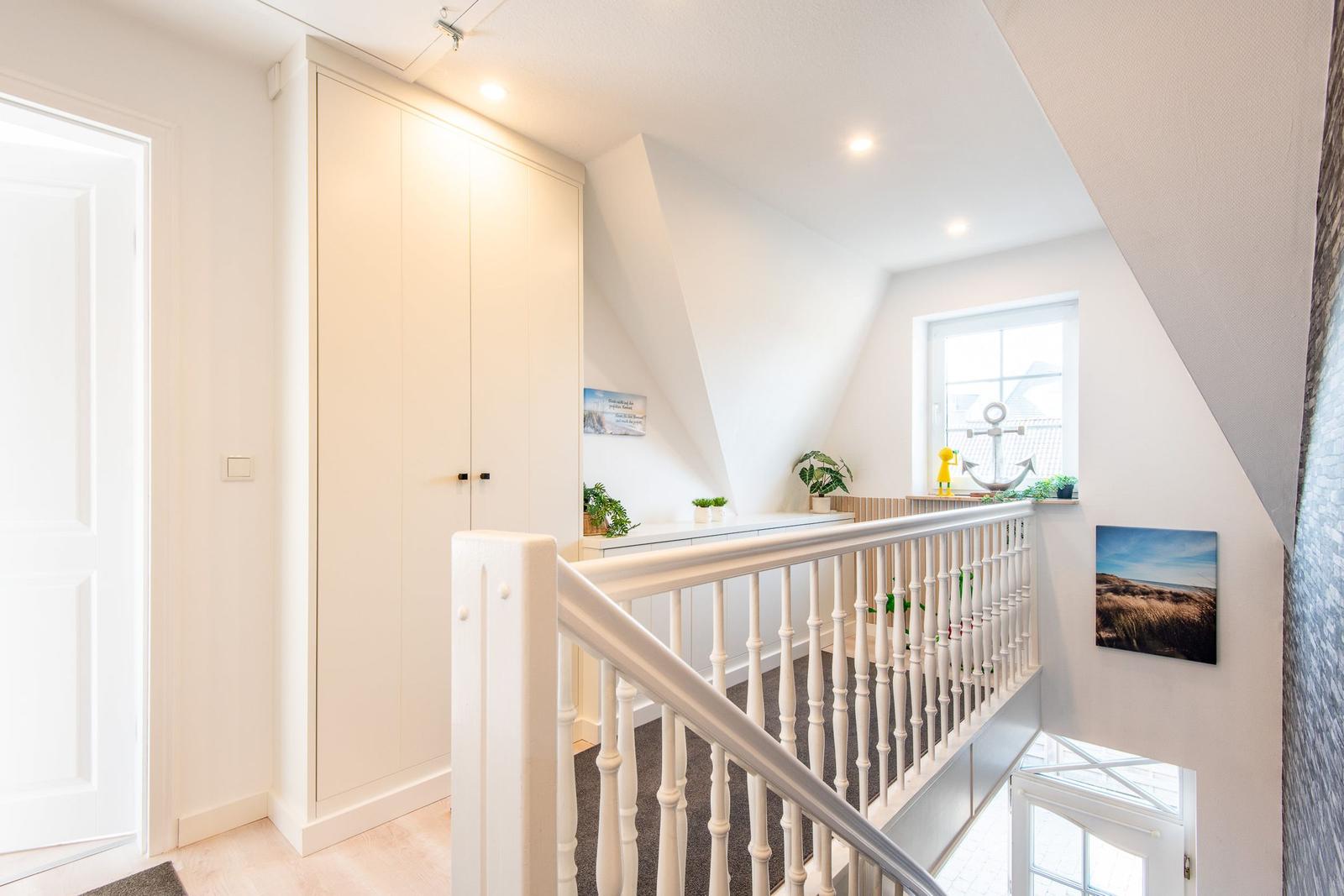 Haus mit Treppe, Garderobe und Fenster. Wandbild und Ankerdekoration sichtbar.