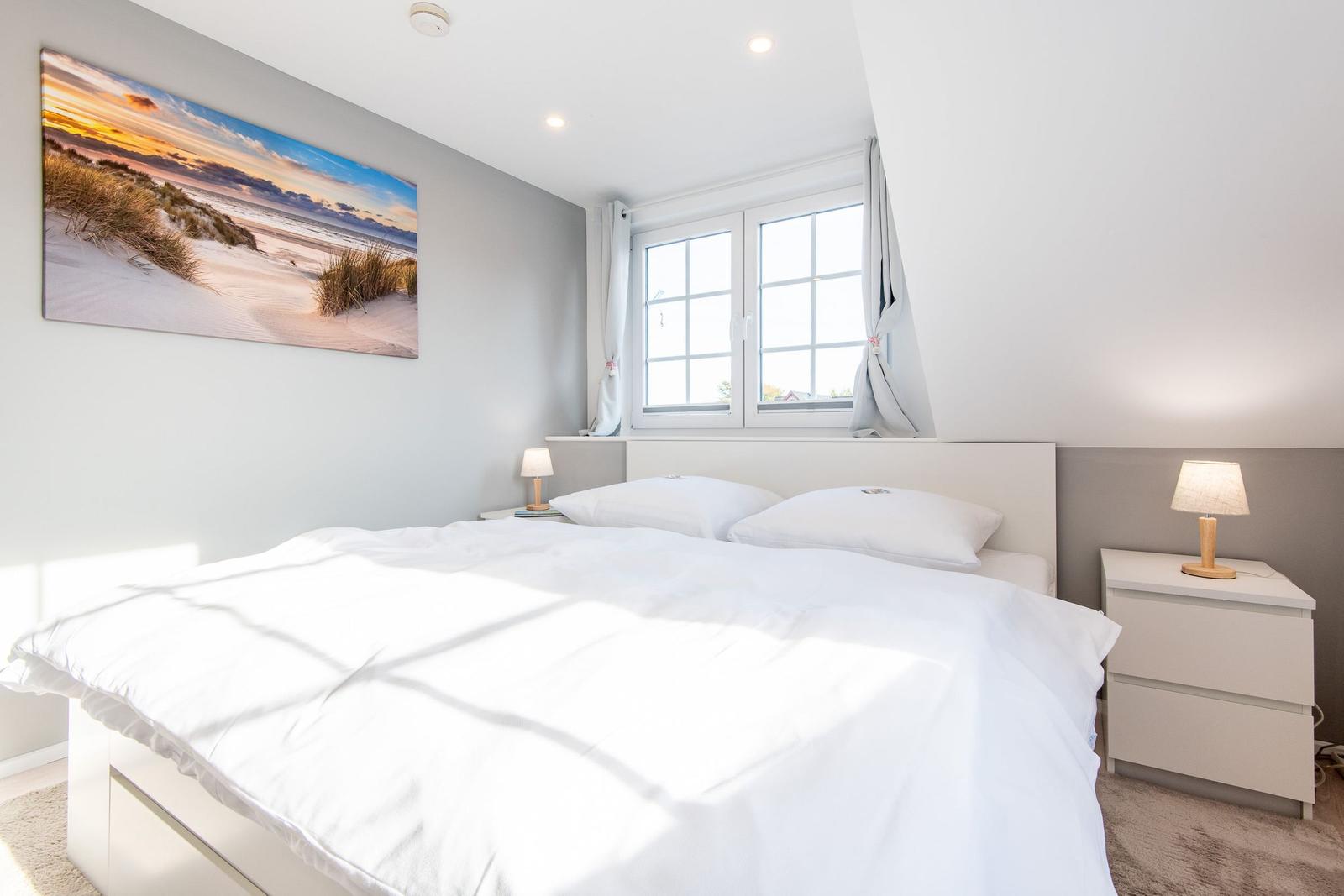 Schlafzimmer mit Doppelbett, Fenster und Wandbild